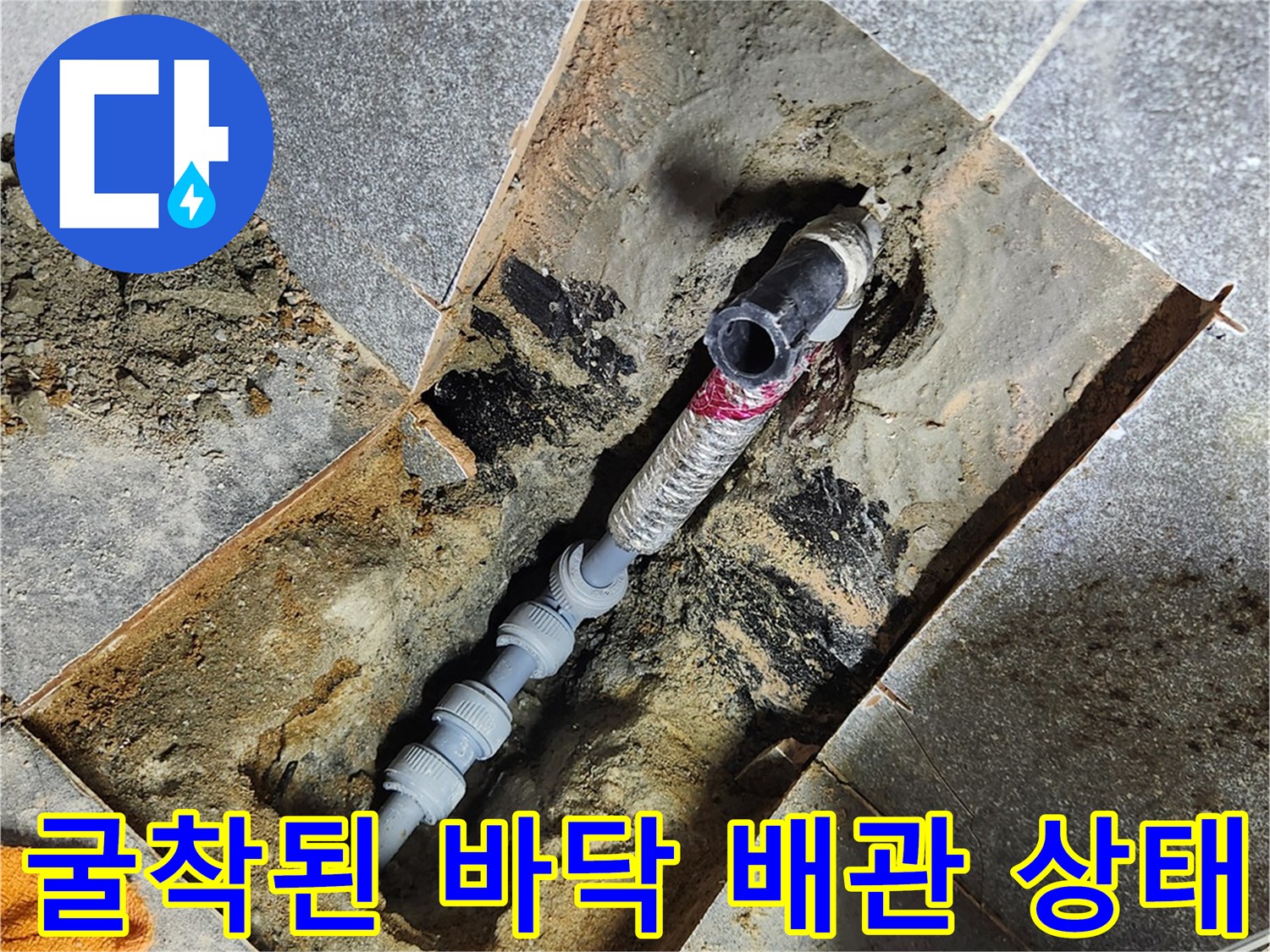 화장실 타일 아래 굴착되어 드러난 수도 배관의 손상 부위