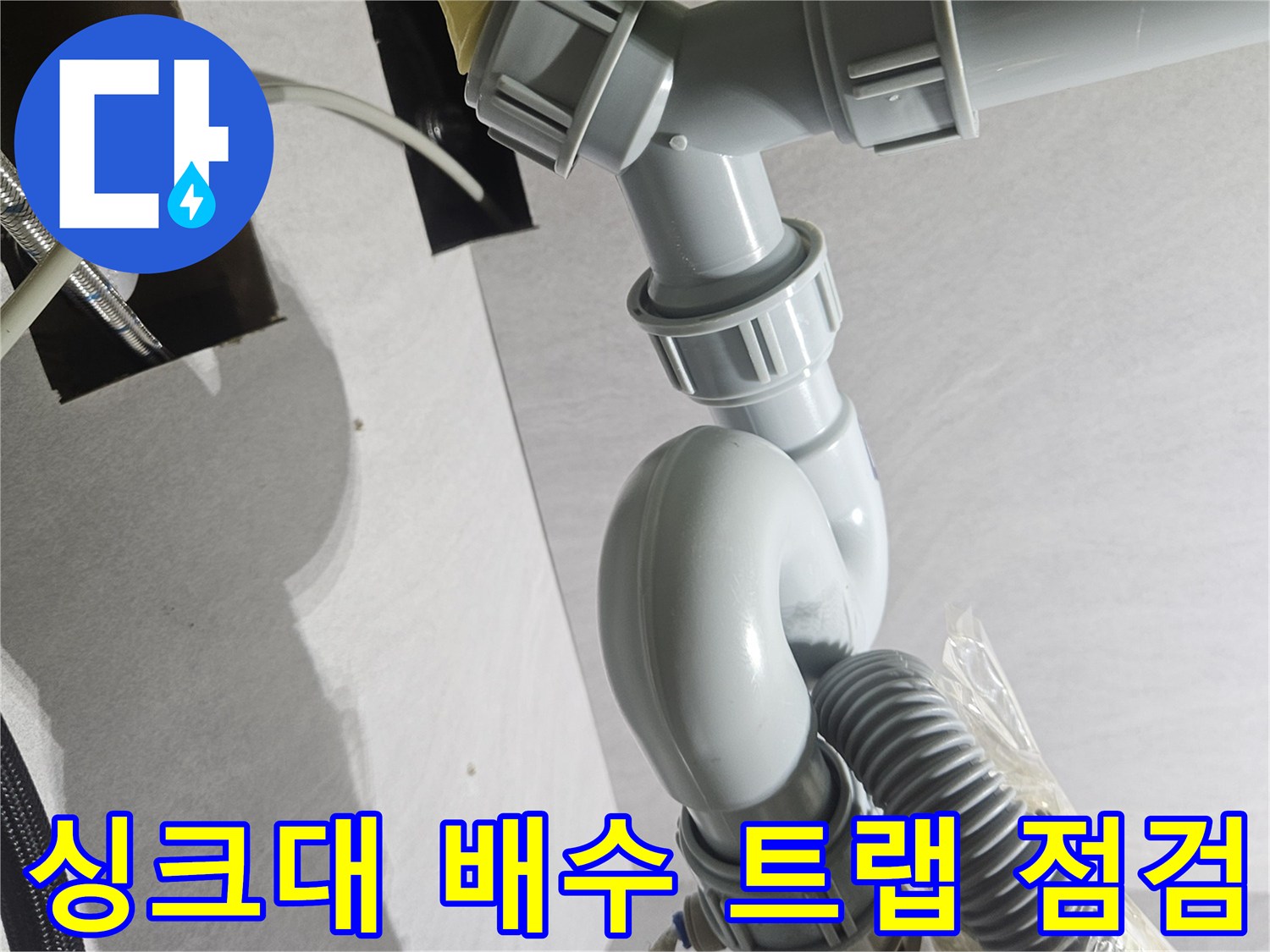 물기가 맺힌 싱크대 하부 주름 호스와 연결 소켓의 모습입니다.