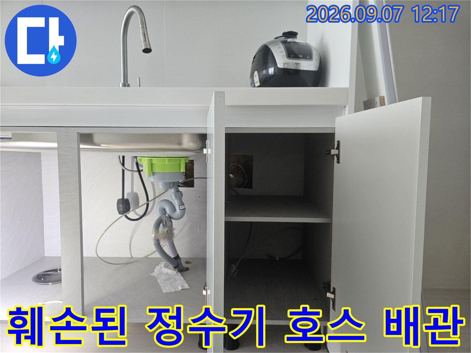싱크대 하단에 연결된 훼손된 정수기 호스와 배관 부위