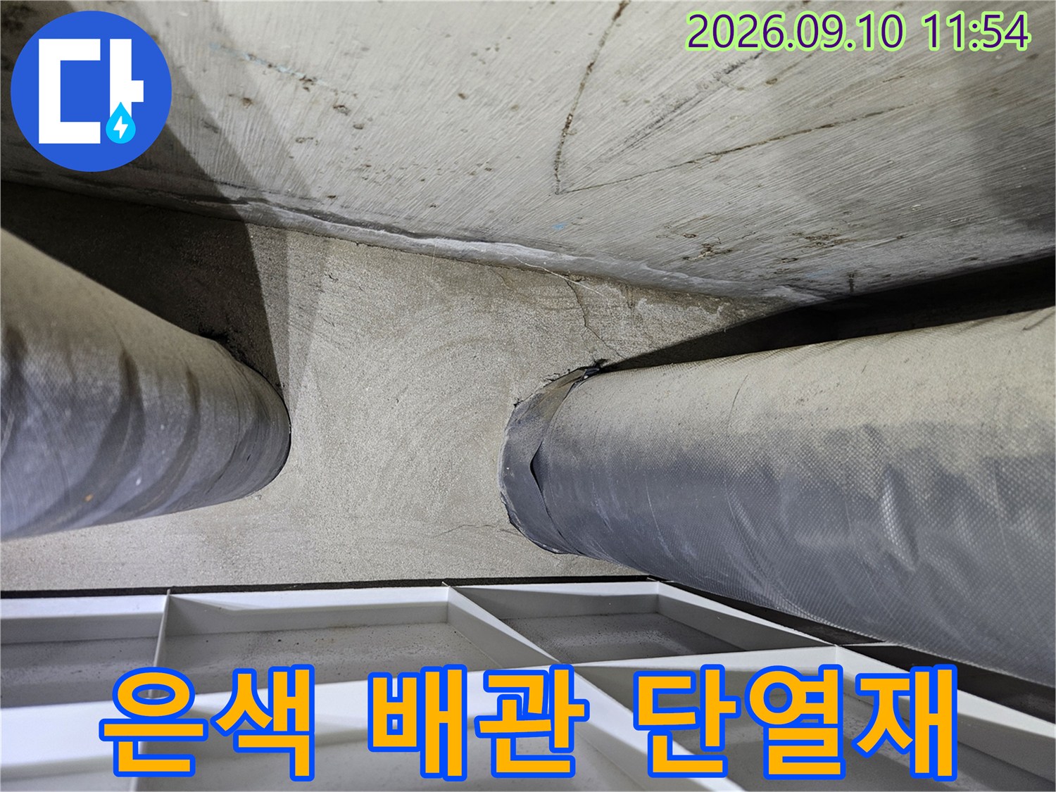단열재로 마감된 두 개의 굵은 배관이 천장에 설치된 모습