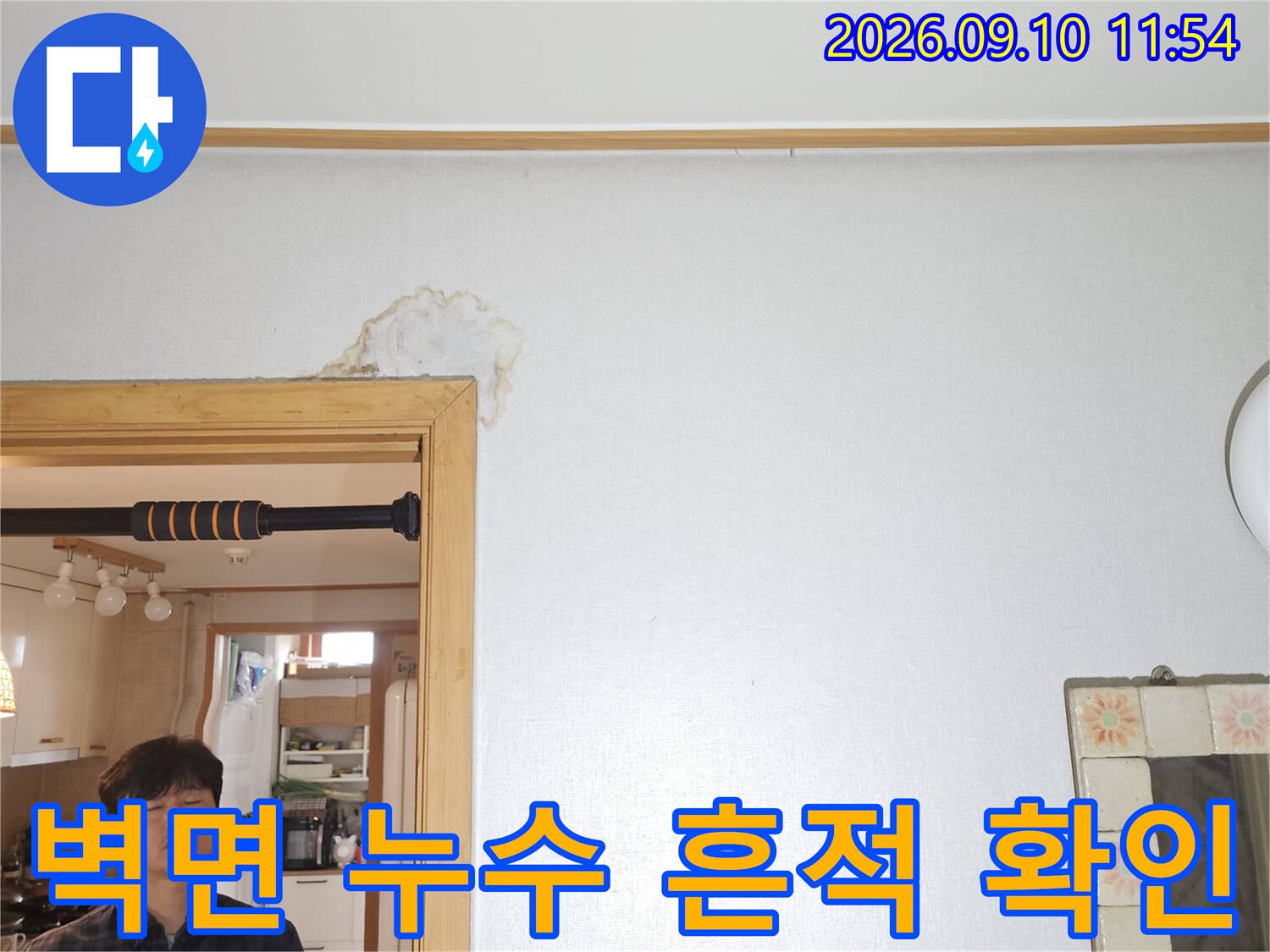 문틀 위쪽 벽지가 물에 젖어 얼룩진 현장 사진입니다.