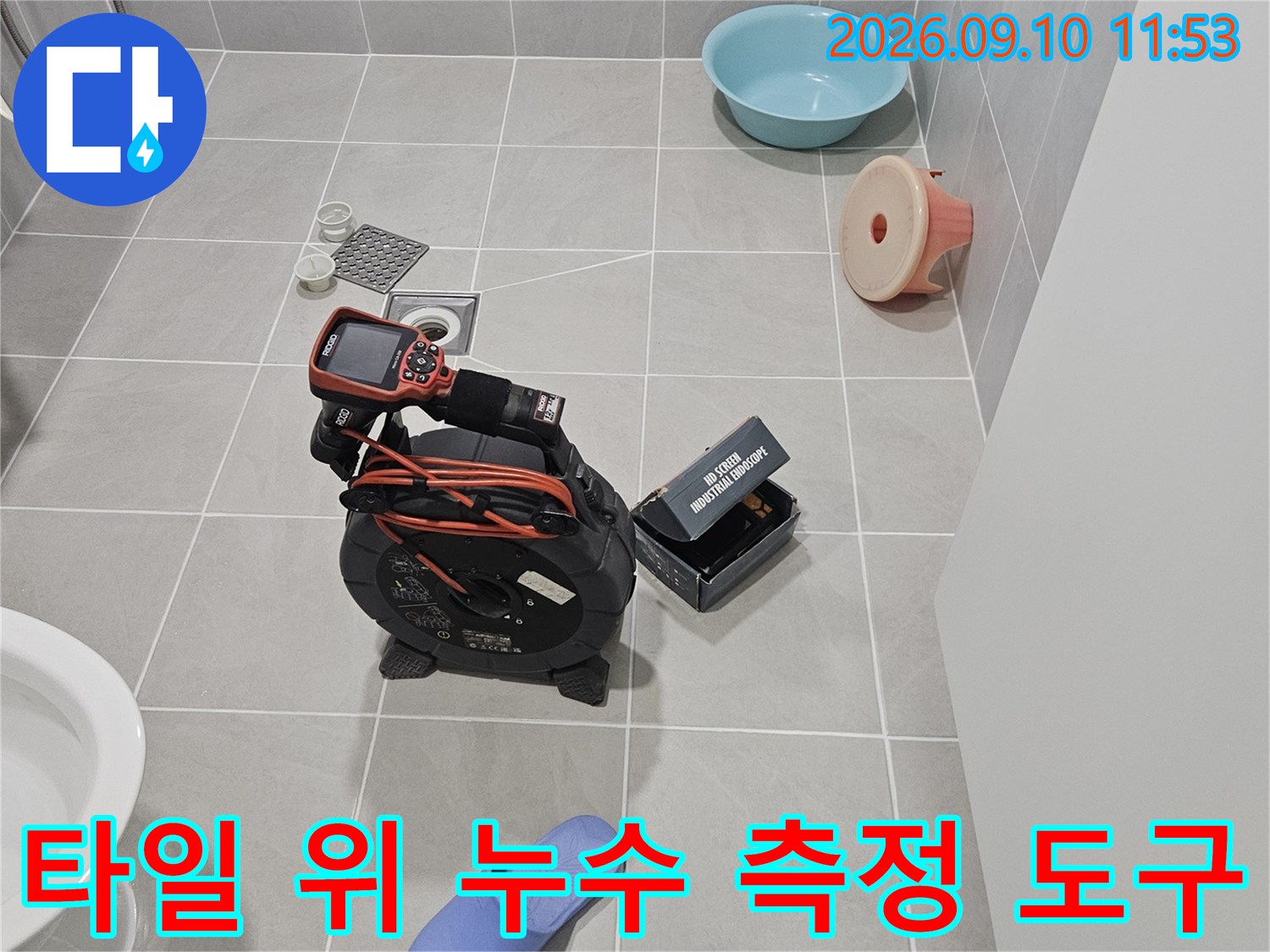 욕실 타일 위에 놓인-디지털 계측기와-누수 탐지 장비