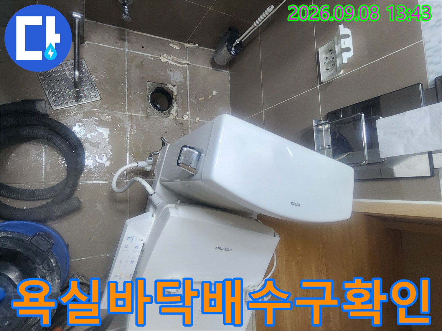 변기-뒤쪽-배수구-주변의-젖은-타일과-노출된-배관-모습