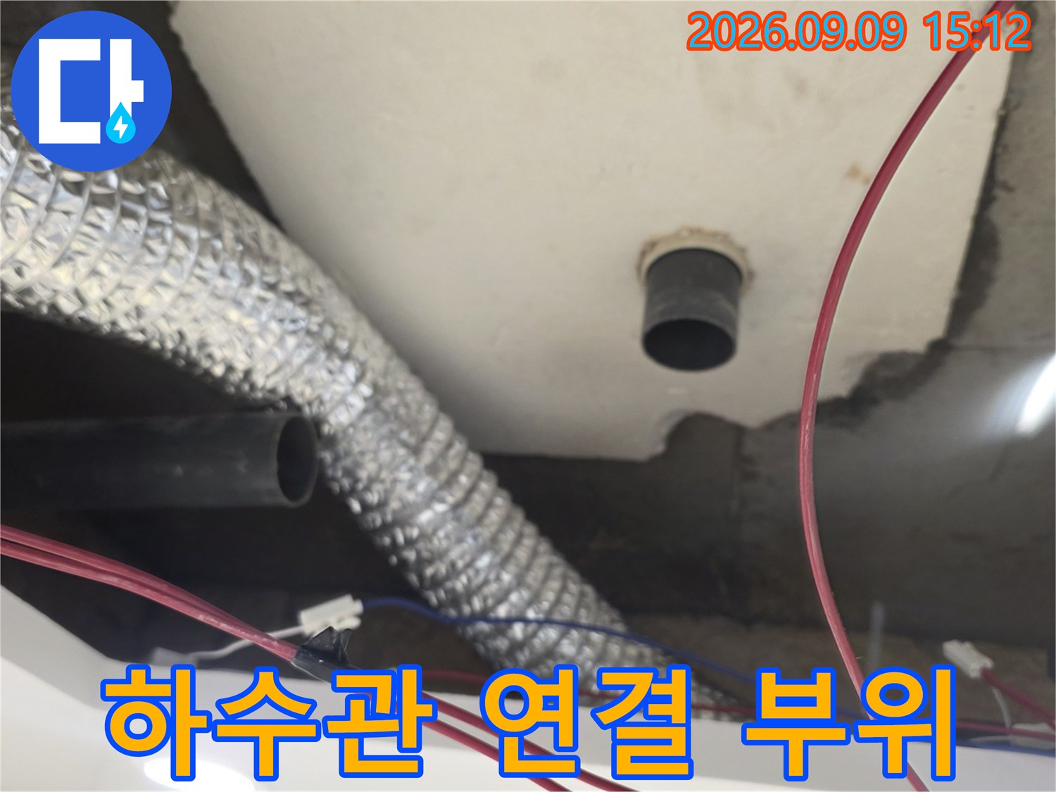 천장 구조물 사이로 노출된 하수 배관과 은박 보온재 배관의 상세 모습