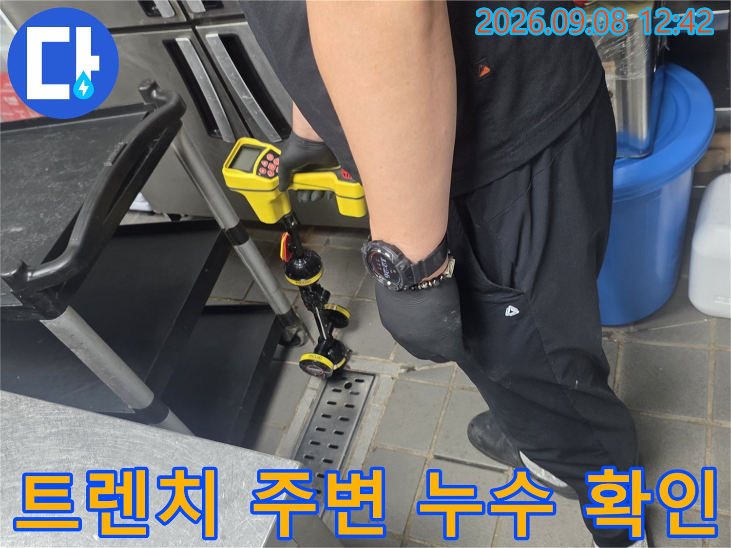 주방 트렌치와 배관 연결 부위의 습기 상태를 점검하는 작업 현장