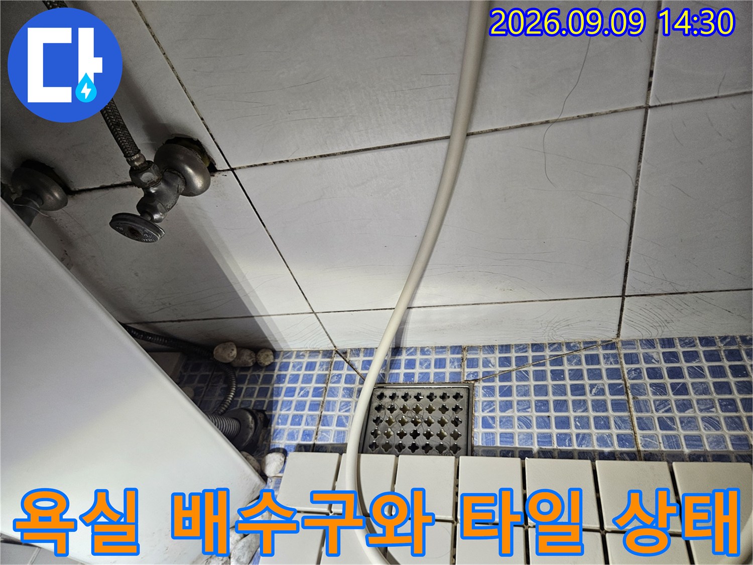 송파구 석촌동 욕실의 파란색 모자이크 타일과 바닥 배수구 및 수도 배관 모습입니다.