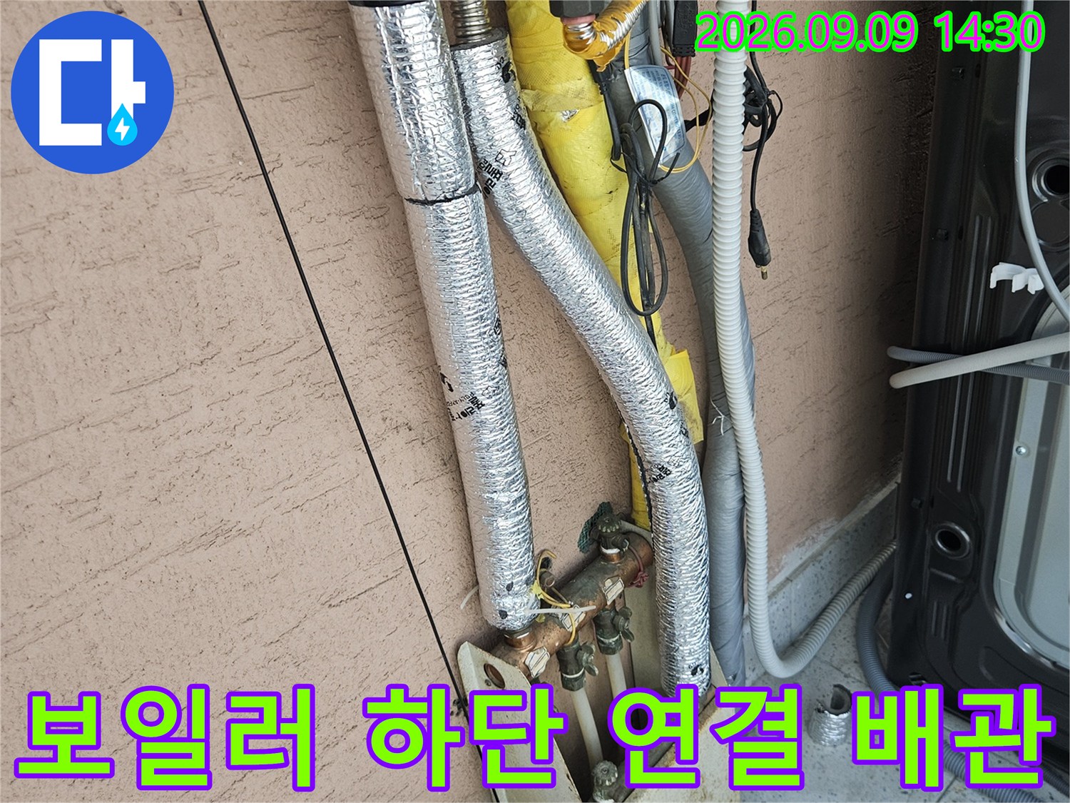 은색 단열재로 감싸진 보일러 배관과 벽면 쪽으로 연결되는 구조물