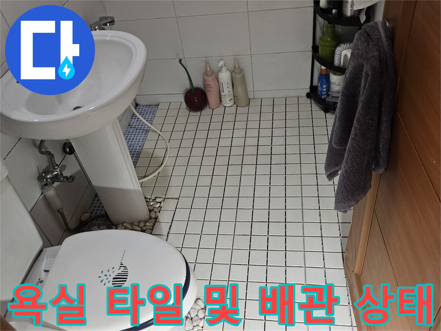 화장실 세면대 하단-배관 연결 부위의 마감 상태를 촬영한 사진입니다.