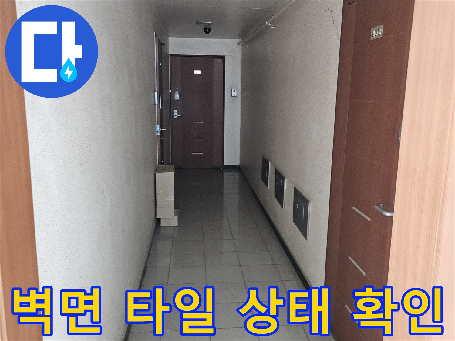 회색 벽타일과 갈색 천장 마감재가 보이는 실내 복도 공간의 모습입니다.