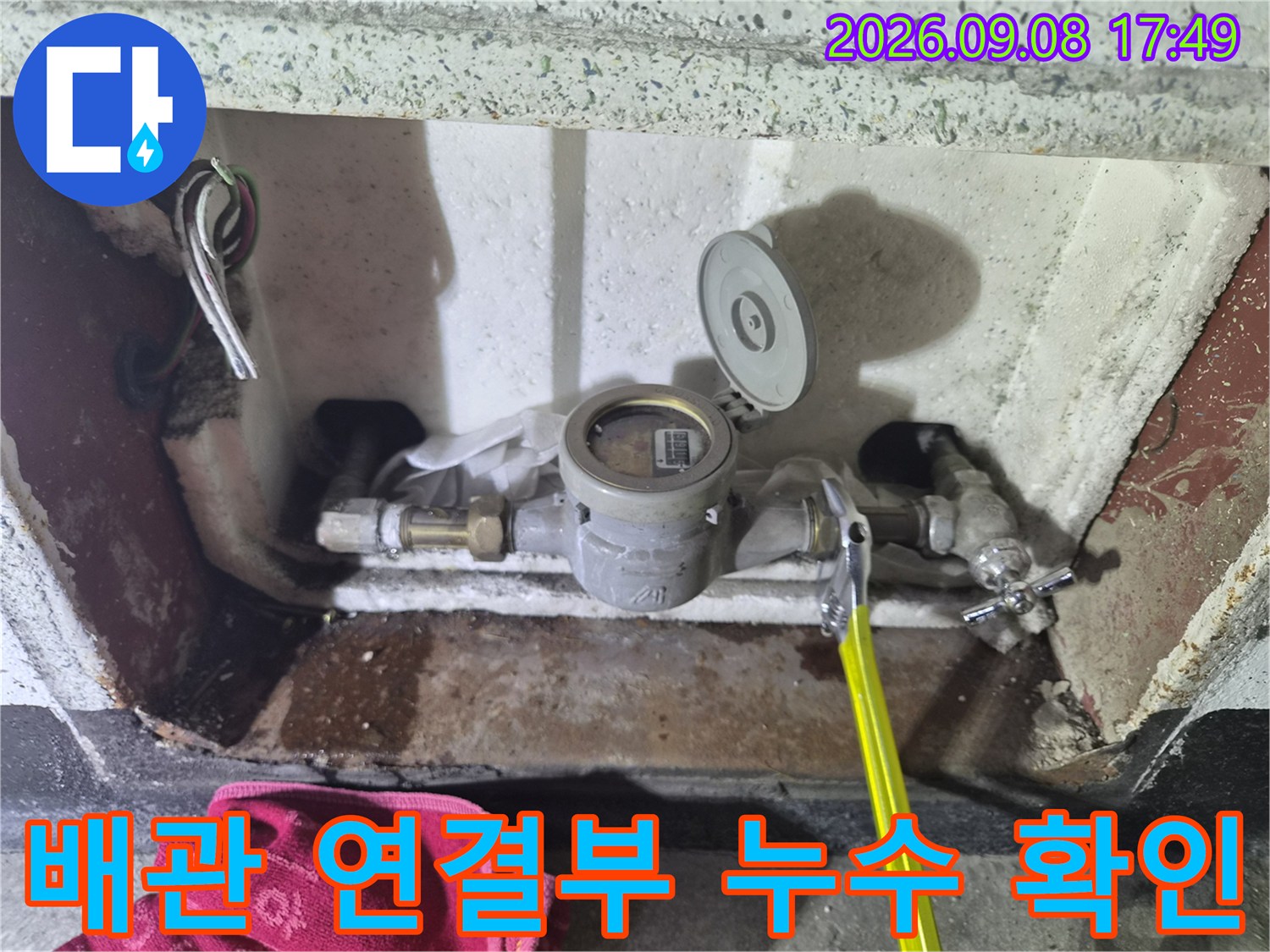 수도 계량기와 배관의 금속 연결 부위가 젖어 있는 모습입니다.