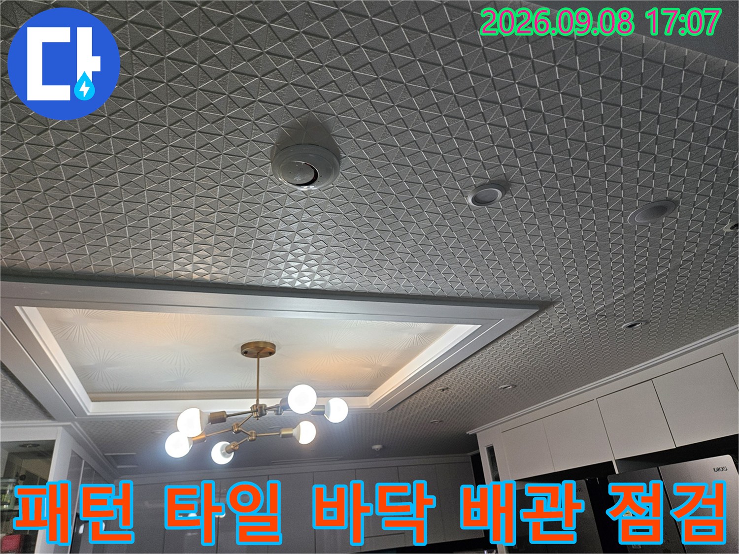 세탁실 내부의 기하학적 문양 타일과 매립형 조명 시설물