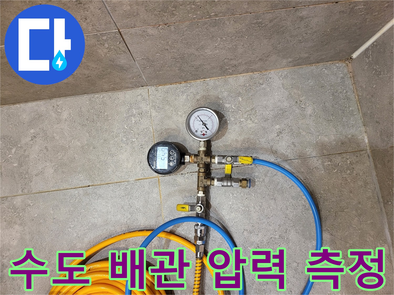 배관 연결 부위에 설치된 압력 측정 장비와 파란색 호스