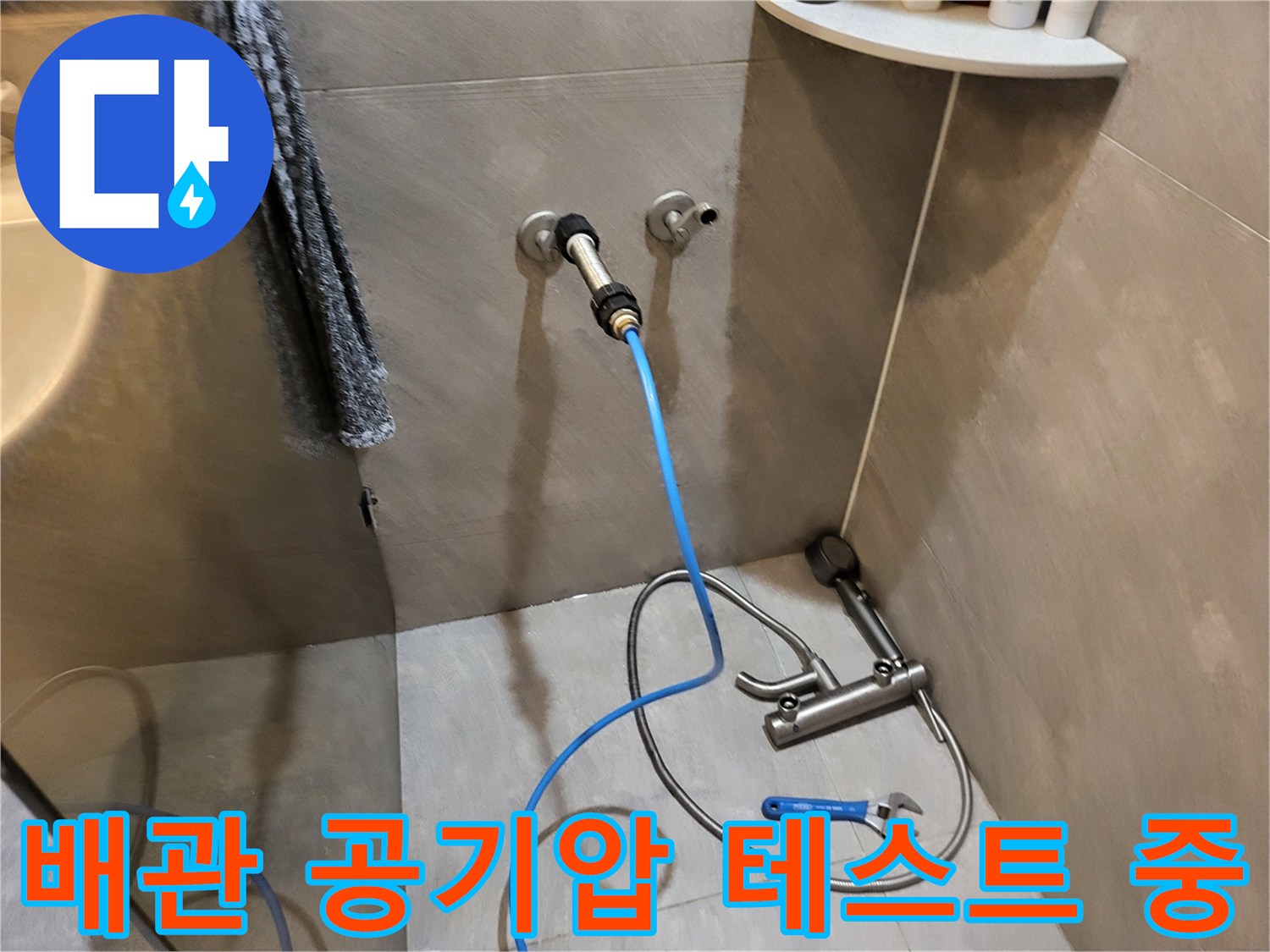 벽면 수도 꼭지 부근에 연결된 파란색 압력 측정 호스