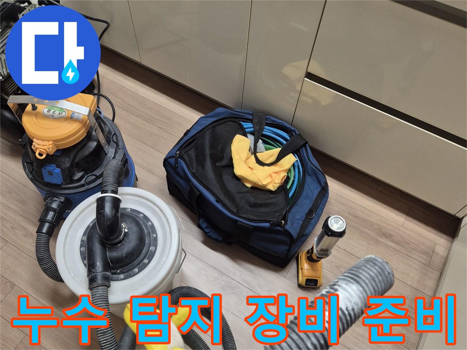 바닥에 배치된 누수 진단용 게이지와 호스 및 청소 도구들