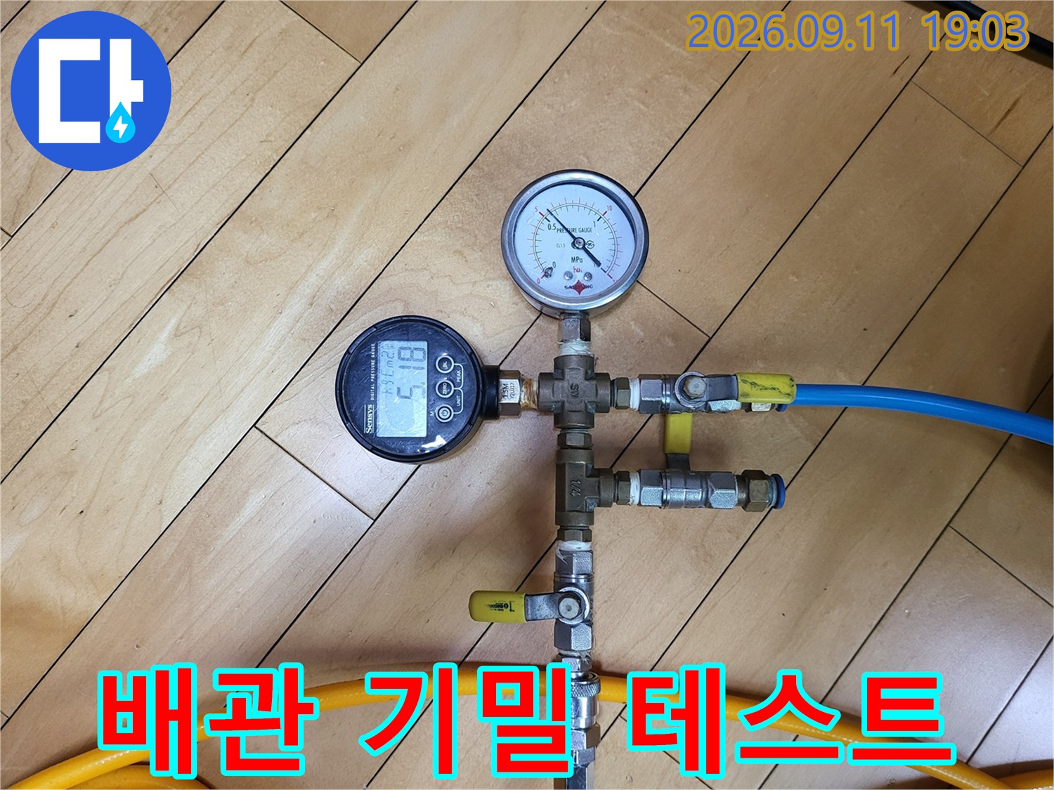 노란색과 파란색 호스가 연결된-배관 압력 측정 장비