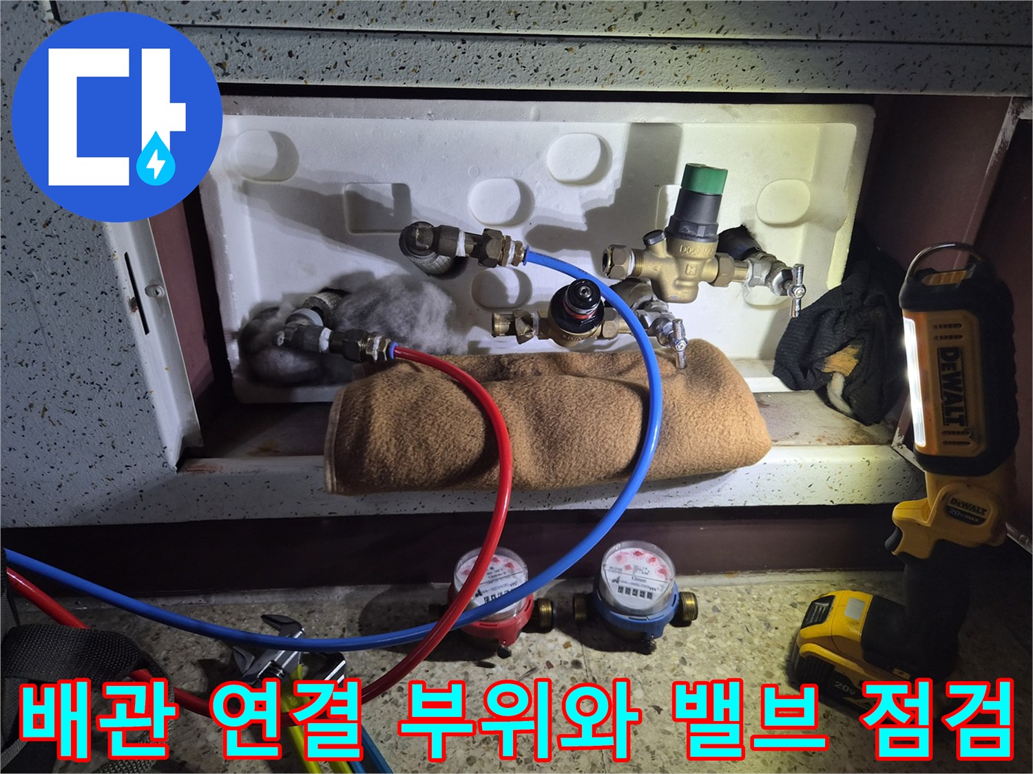 수도 밸브와 계량기 주변의 배관 설비를 정밀하게 조사하는 장면