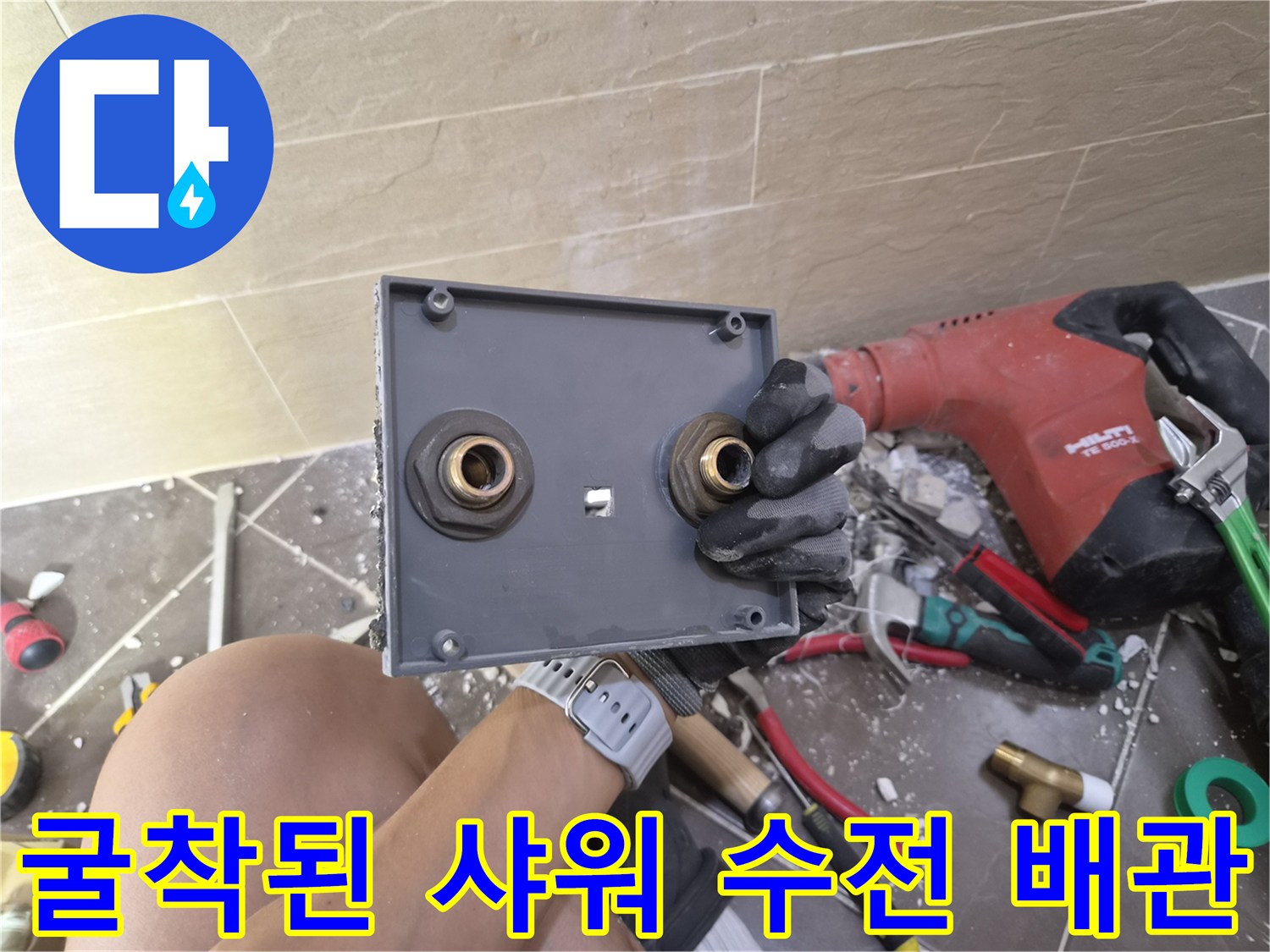 샤워 수전 설치를 위해 타일을 제거하고 내부 배관을 확인하는 작업 현장입니다.