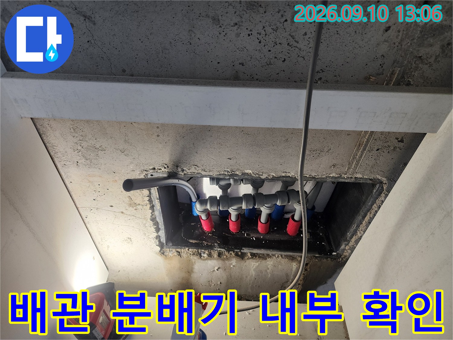 매립된 배관 분배기의 연결 부위와 라인을 촬영한 사진입니다.