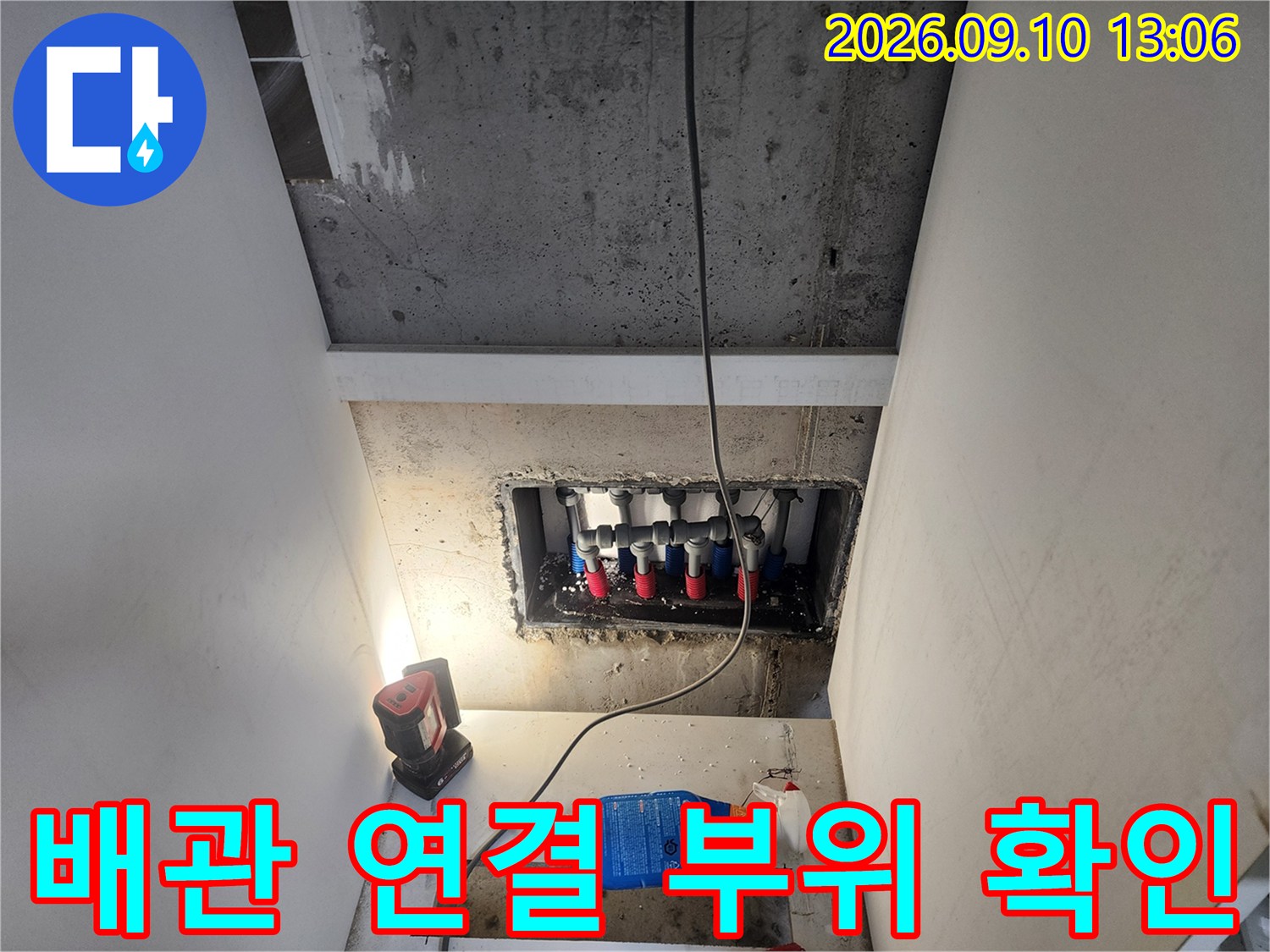 배관 분배기 연결 부위의 누수 여부를 점검하는 현장 사진