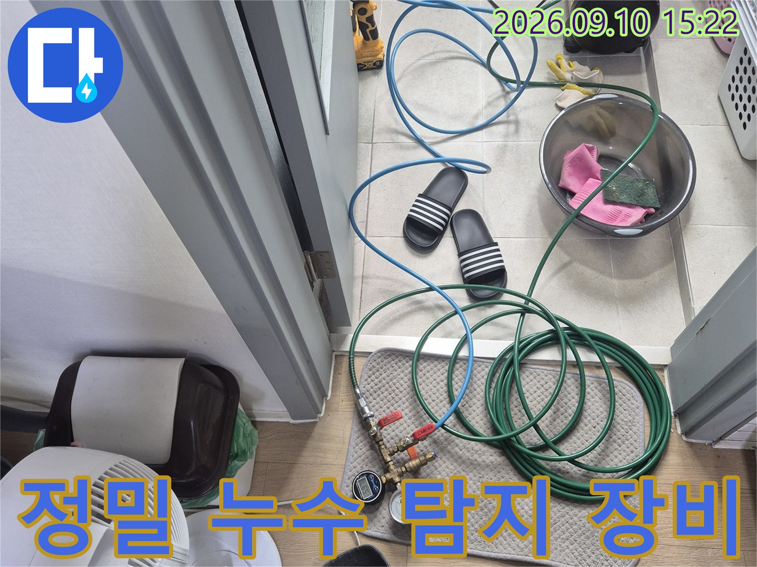 누수 지점을 찾기 위해 바닥에 배치된 공압 테스트용 압력계와 호스들입니다.