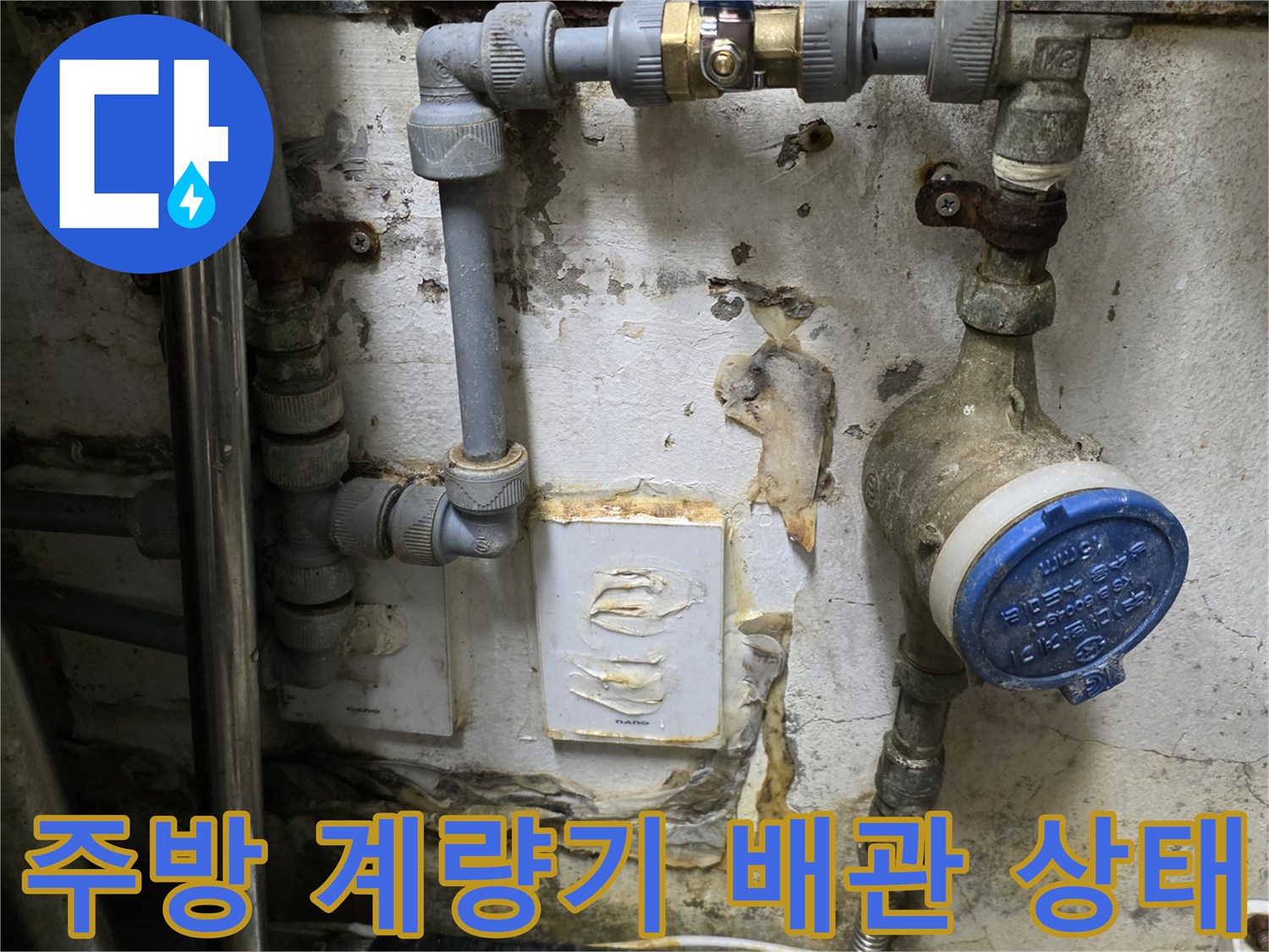 식당 주방 내 설치된 파란색 캡의 수도 계량기와 노후된 연결 배관 모습