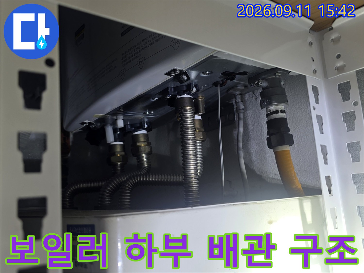 금속 주름관과 노란색 호스가 연결된 보일러 배관 설비 내부 모습