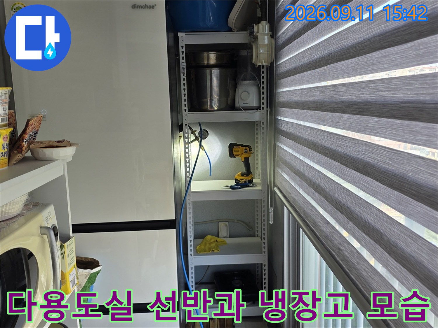 선반 위 물건들과 냉장고가 배치된 주거 공간 사진입니다.