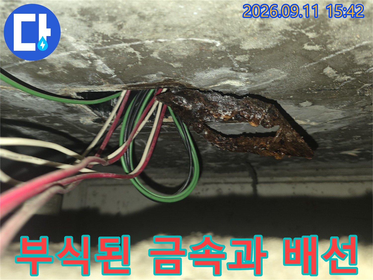 천장 슬라브 아래에-부식되어 녹슨 철제판과 전기 배선
