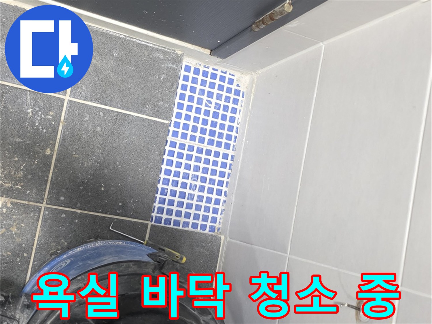 파란색 모자이크 타일과 작업용 청소기의 모습입니다.