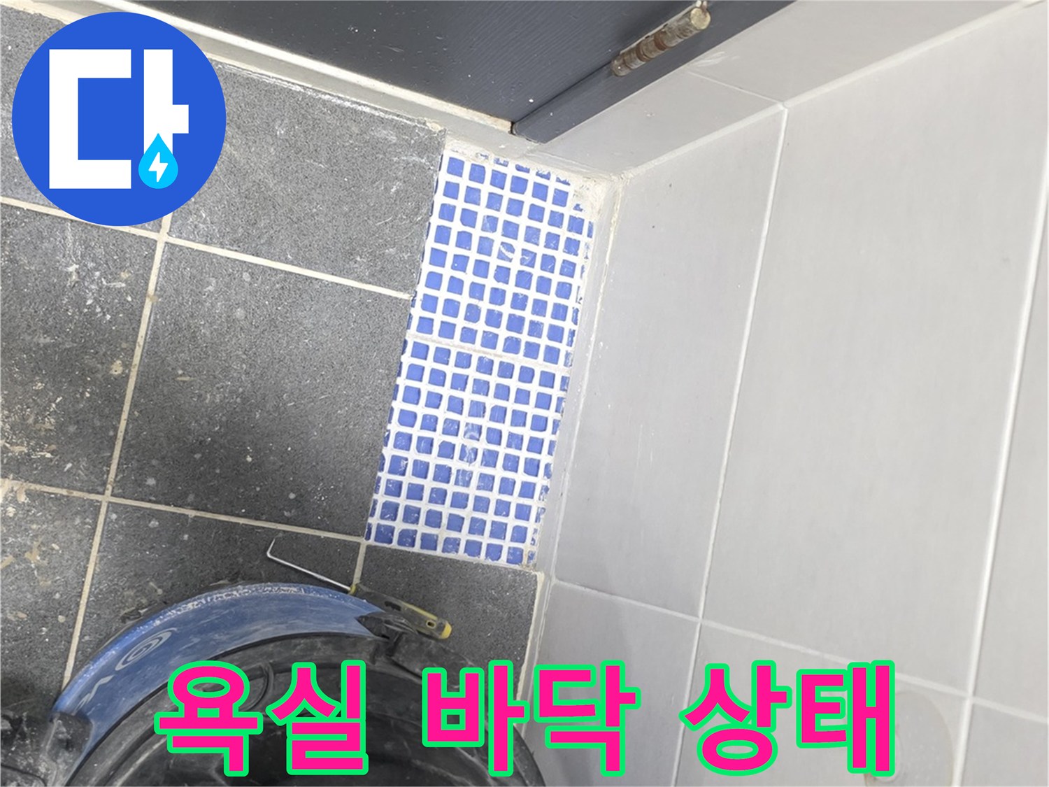 화장실 입구 쪽 파란색 타일과 청소 장비의 모습입니다.