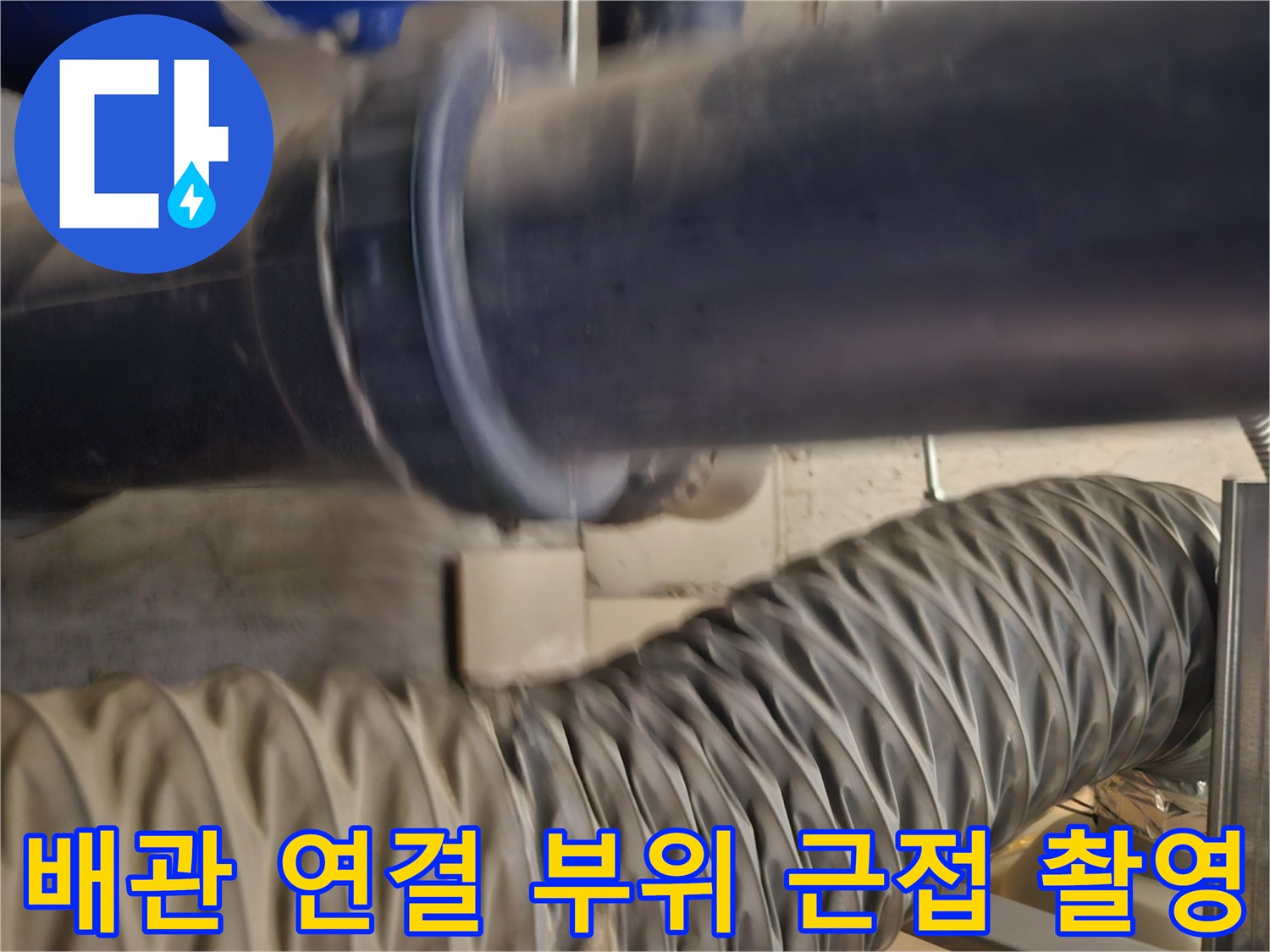 세면대 밑 배관의 굵은 관과 주름 호스 연결 지점 상세 사진