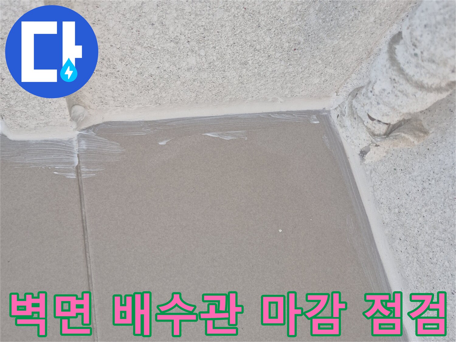 벽체 배수관 접합부의 틈새와 타일 상태를 근접 촬영한 사진