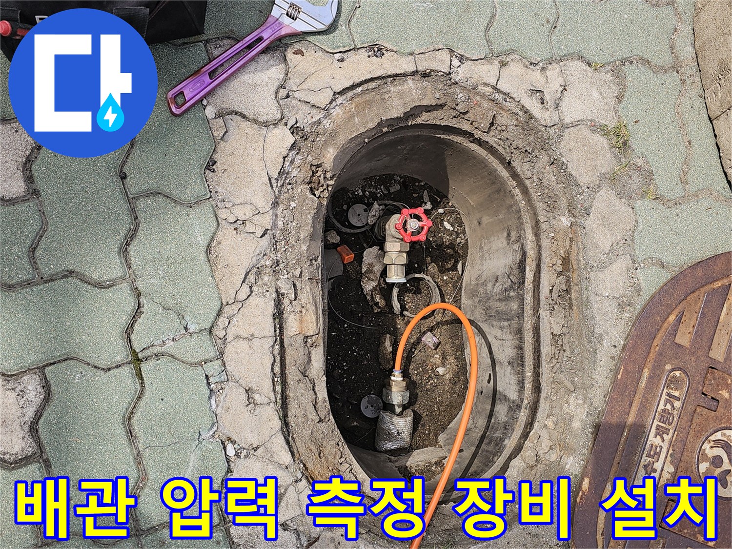 수도 계량기 부근에 설치된 압력 테스트용 호스와 렌치 도구