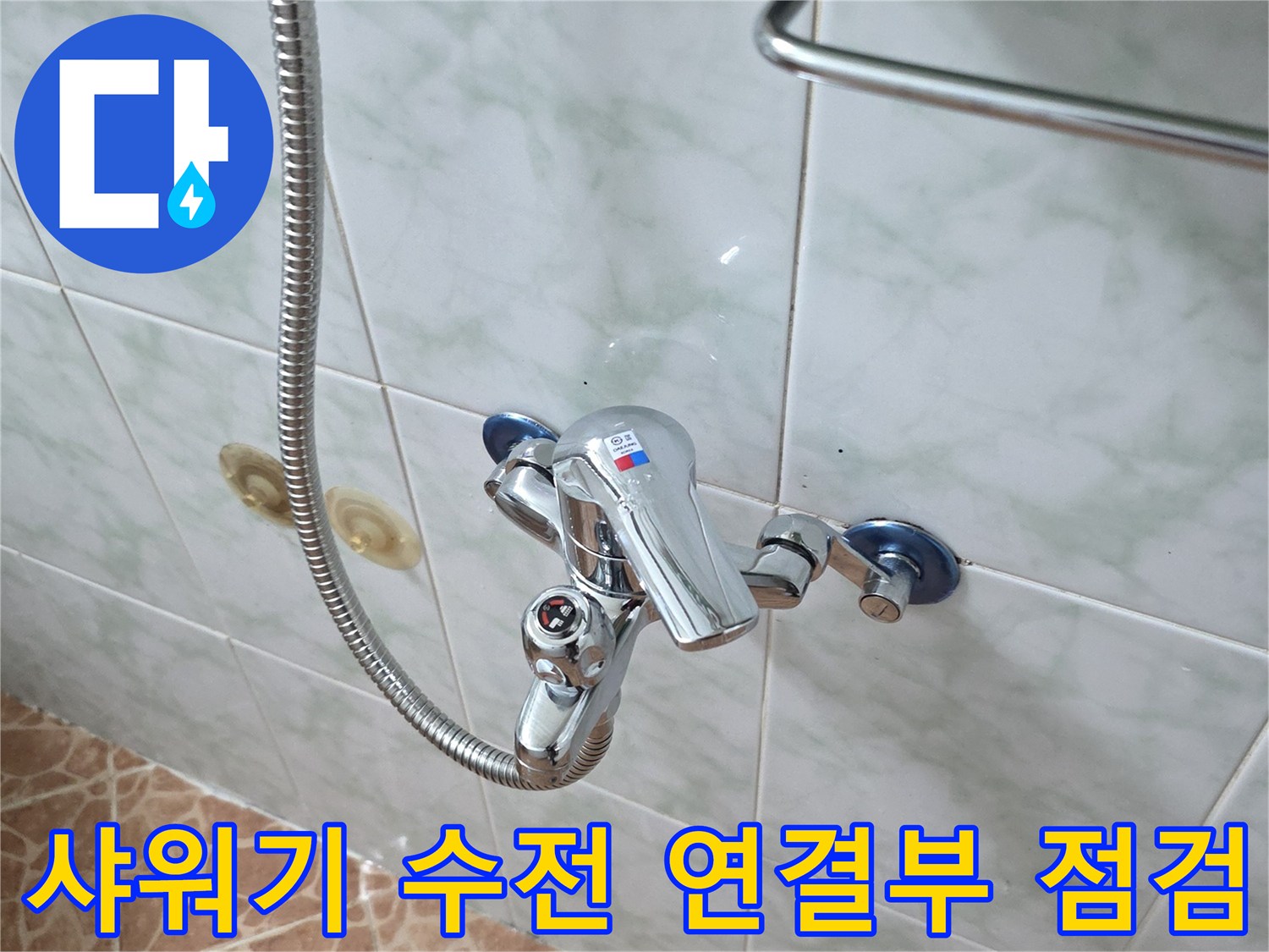 욕실 벽면의 크롬 수전과 샤워 호스 연결 부위 상세 사진