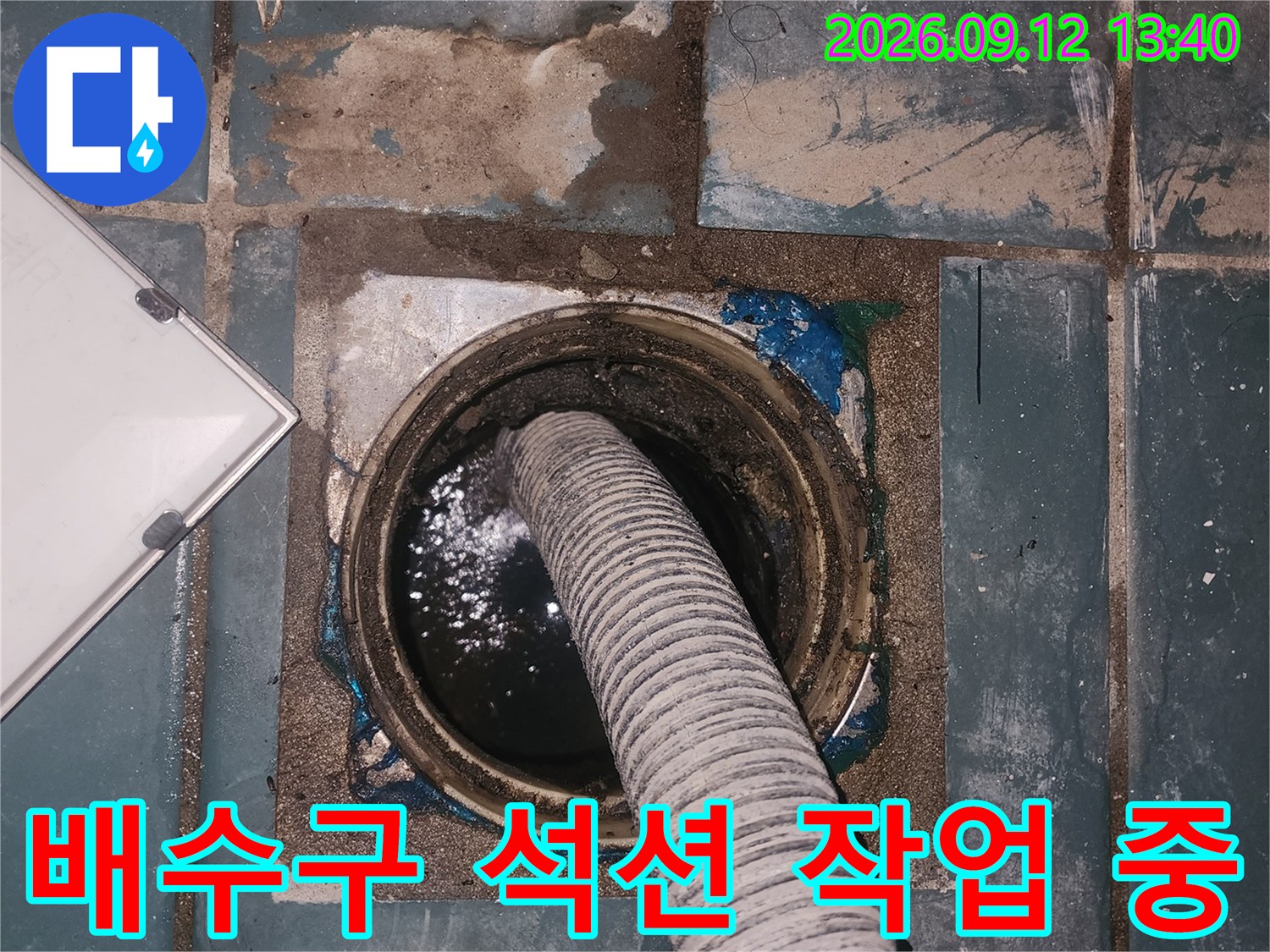 성동구 세탁실 배수구 주변의 물기를 제거하기 위해 석션 장비를 사용하는 모습입니다.