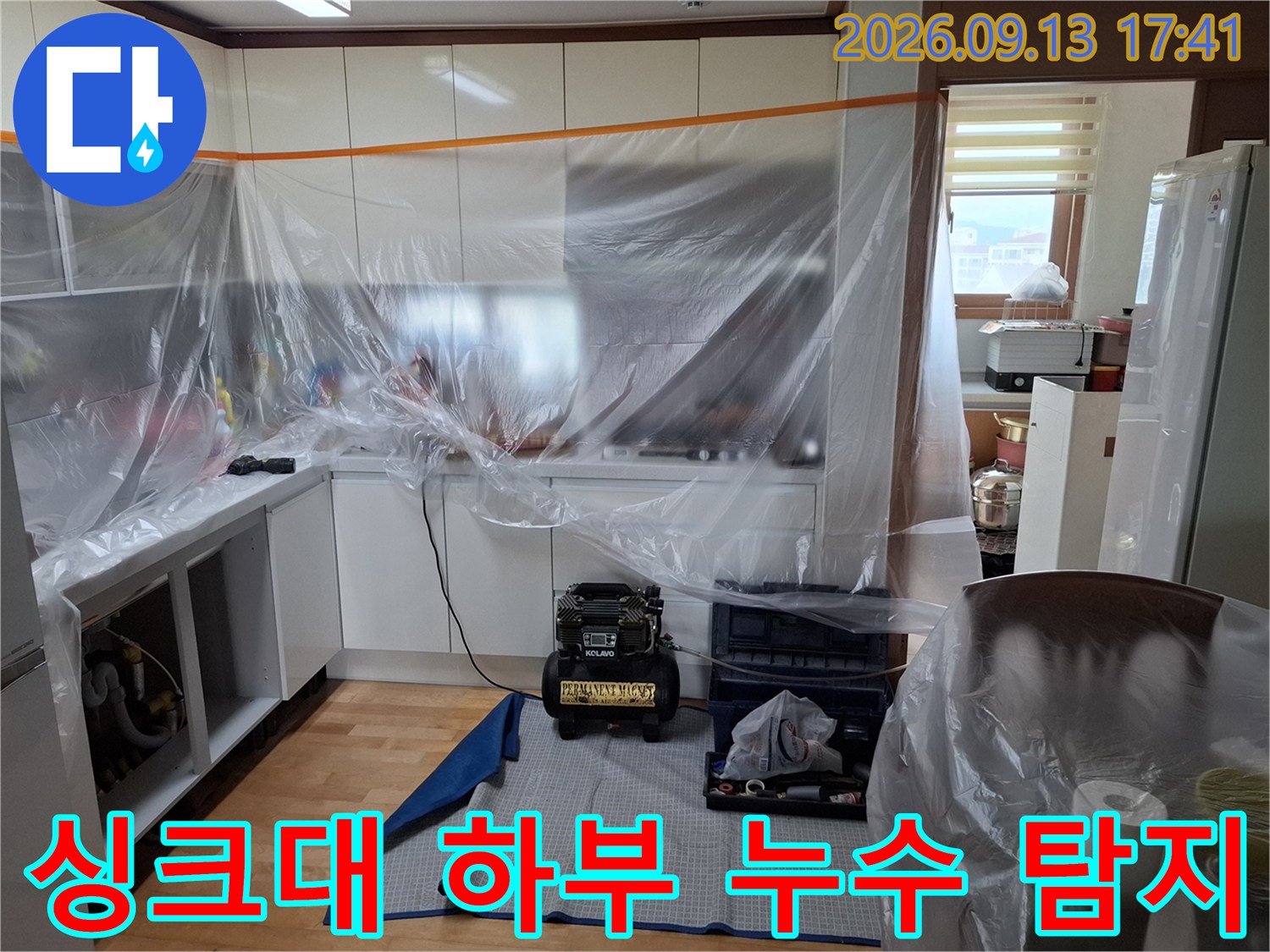 비닐로 덮여있는-싱크대 하부 공간과-누수 탐지를 위한 장비 배치입니다.