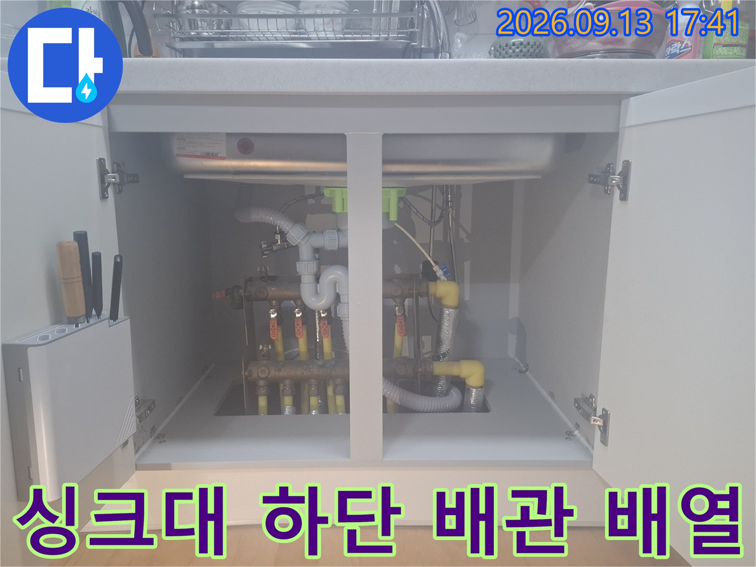 싱크대 밑 분배기 주변에 연결된 다양한 종류의 배관과 부속들입니다.