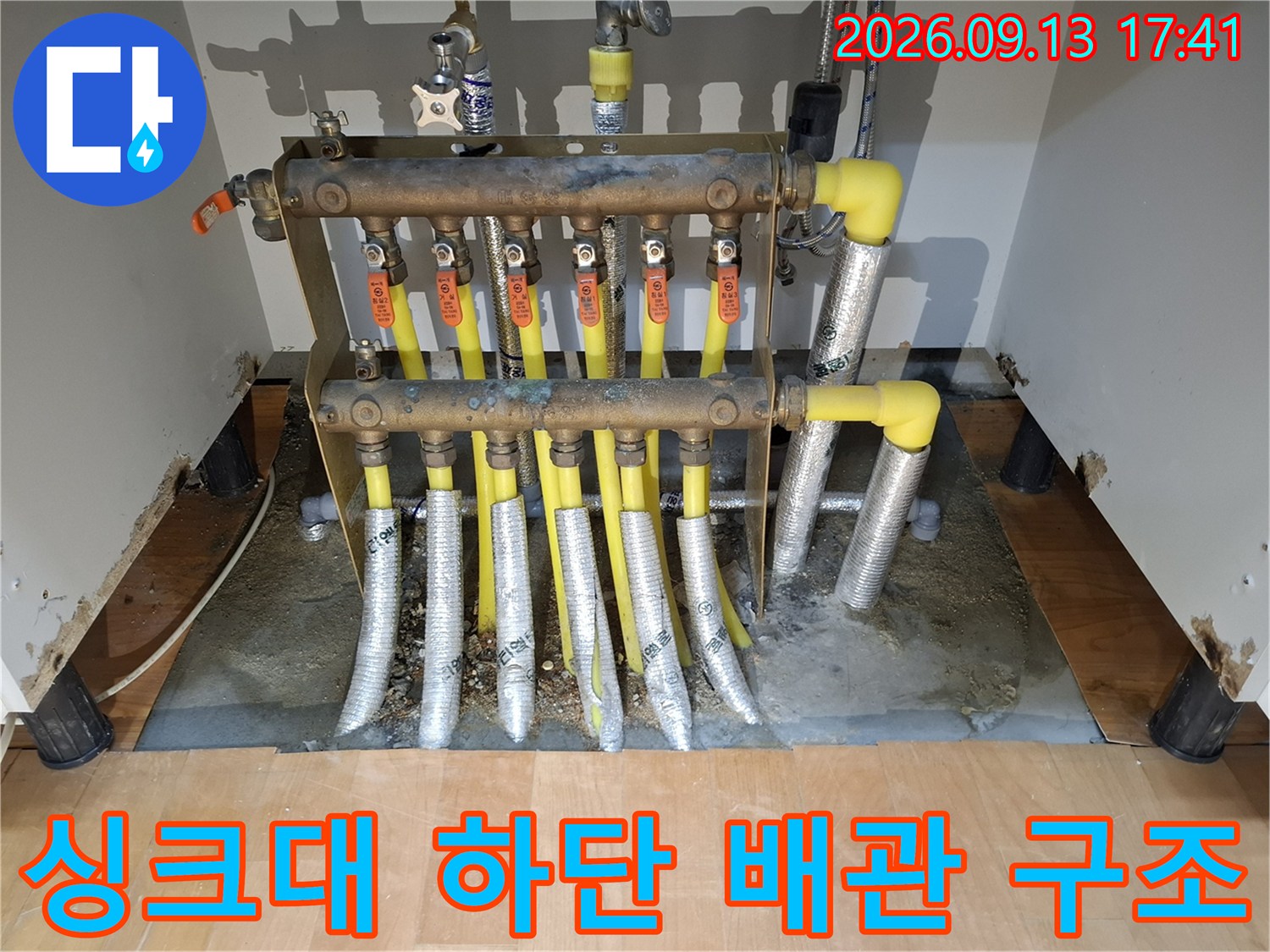 싱크대 아래 설치된 보일러 분배기와 연결 배관의 모습입니다.