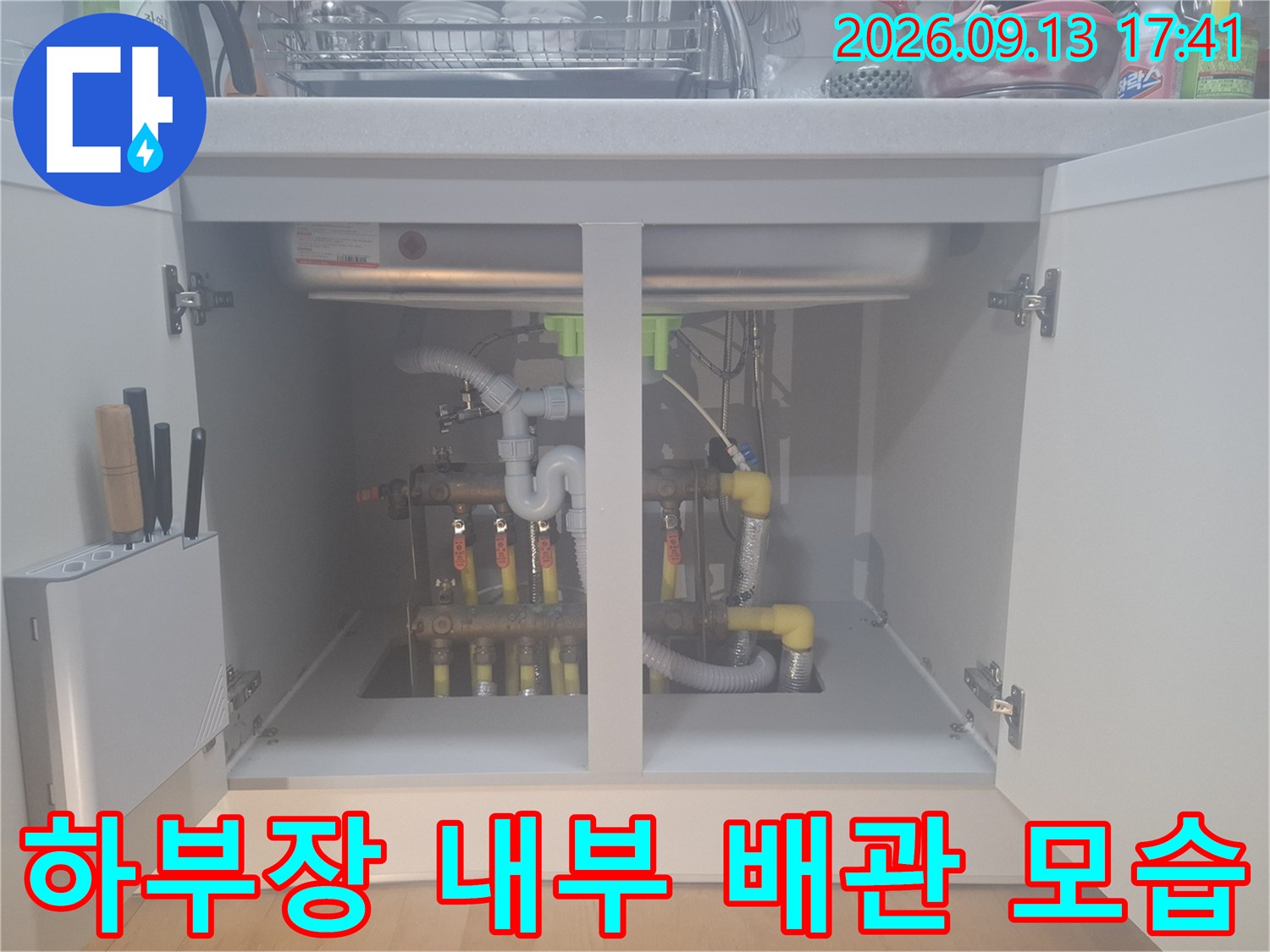 싱크대 아래에 설치된 보일러 분배기와 연결된 다양한 배관들의 상태입니다.