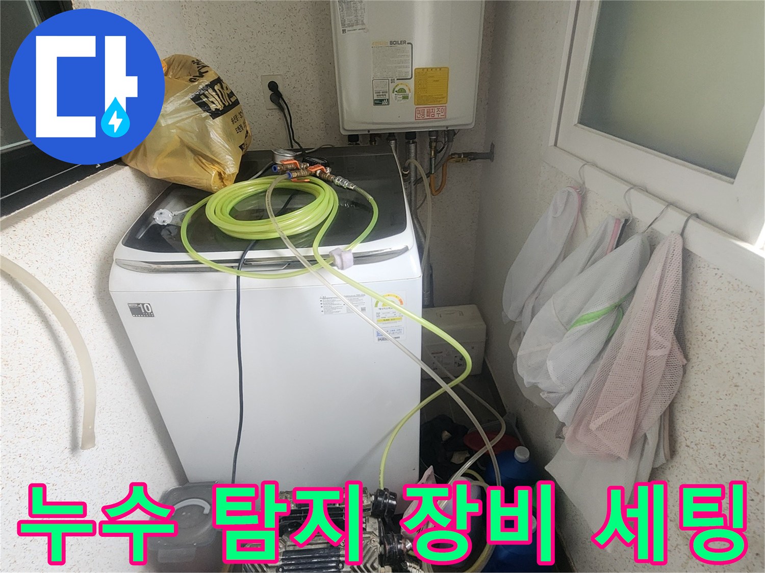 세탁기 옆에 놓인 가스식 누수 탐지기와 호스 릴