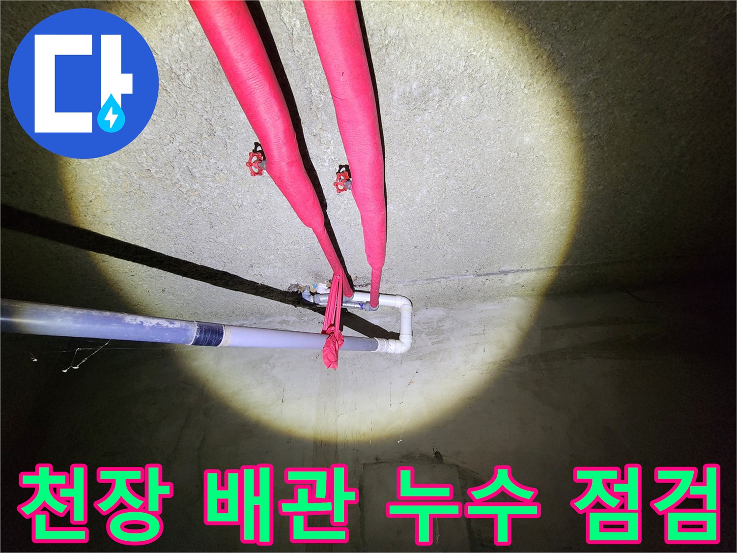 지하 창고 천장에-보온재로 감싸져 있는 난방 배관 라인