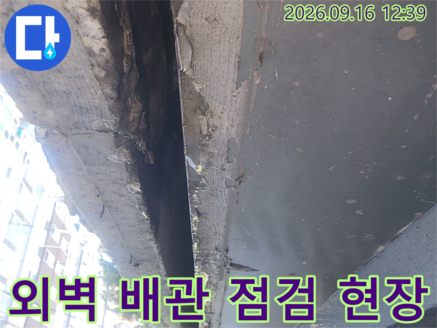 강남구 대치동 건물 외벽의 배관 연결 부위와 노후된 마감 상태를 확인하는 모습입니다.