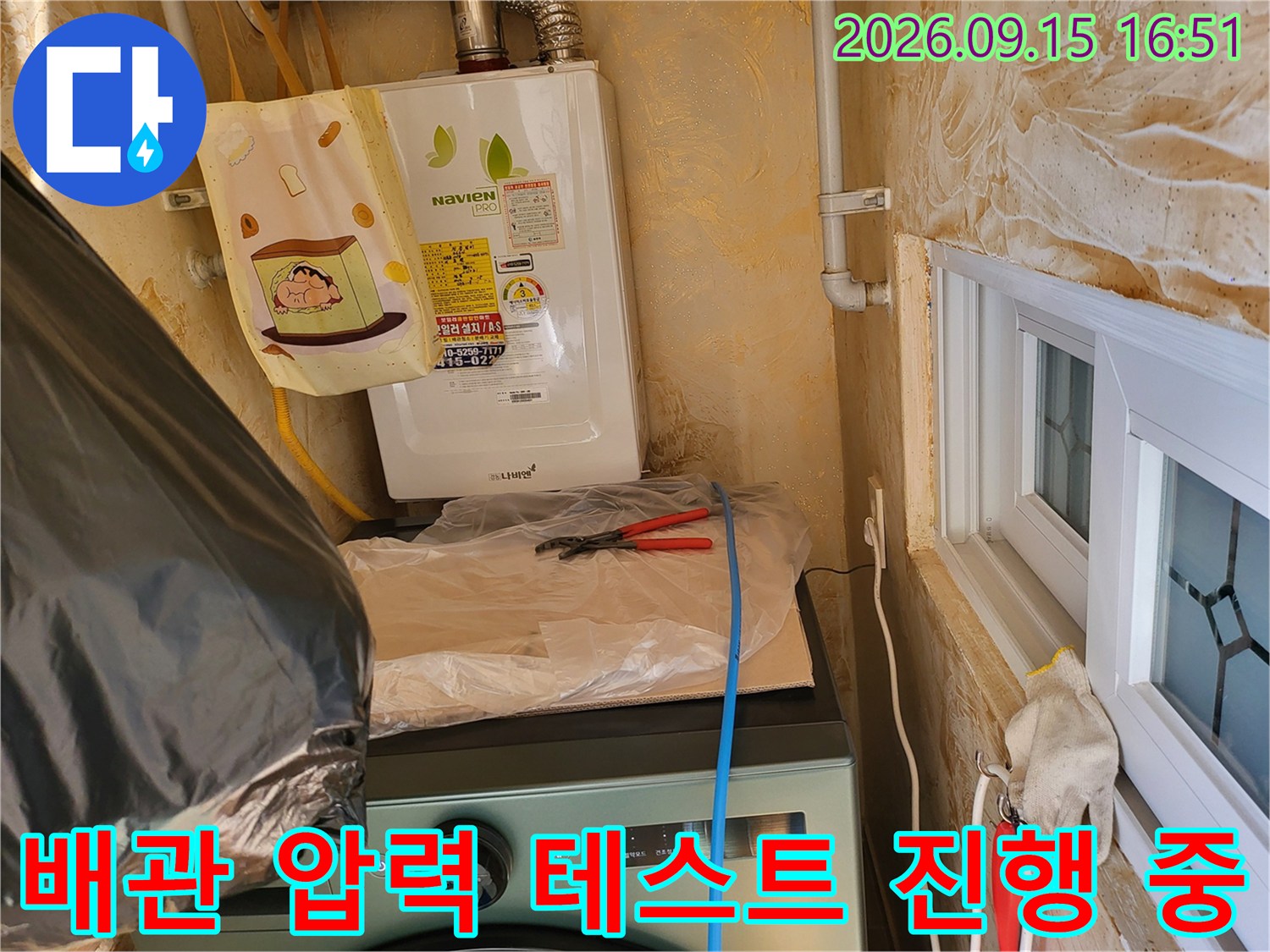 보일러 하단 배관에 압력을 걸어 누수를 확인하는 현장 모습입니다.