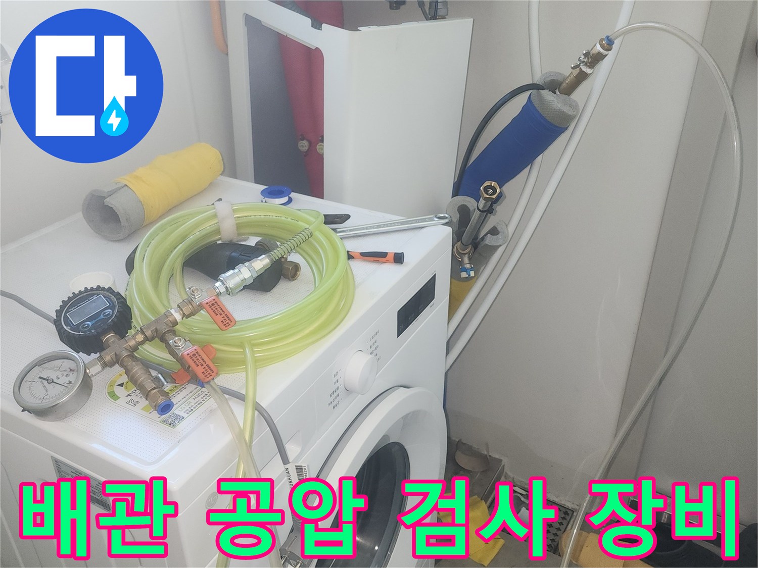 세탁실 배관에 연결된 공압 테스트 장비와 게이지