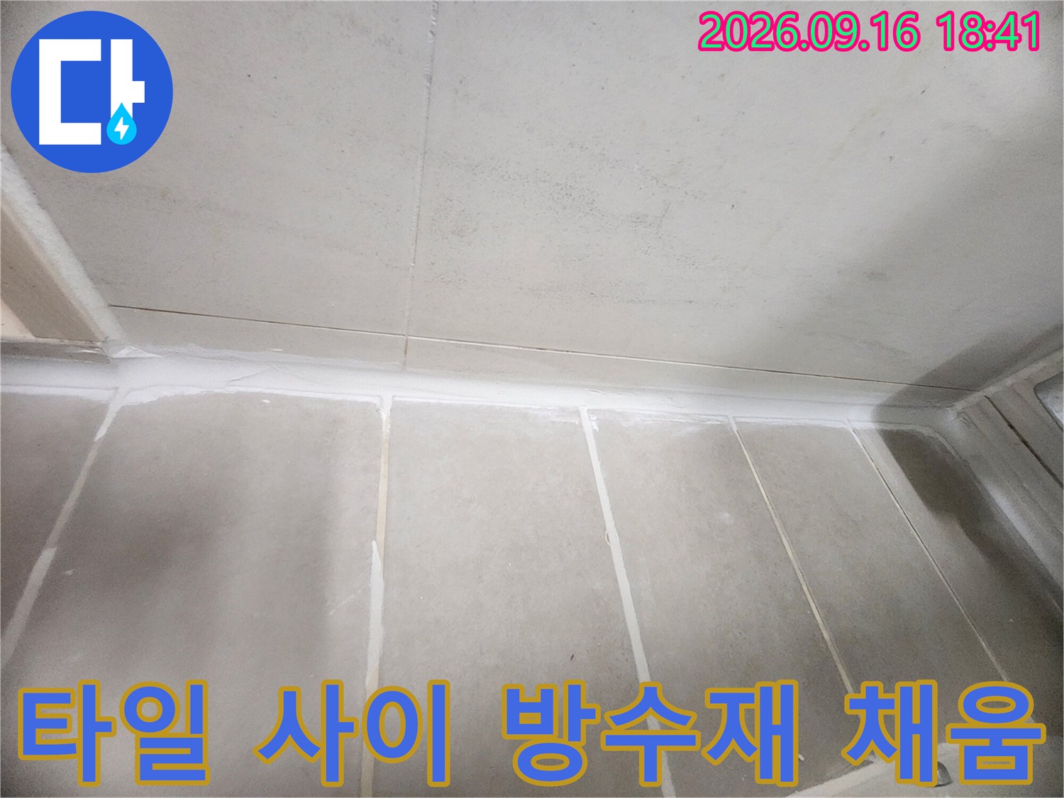 하얀색 방수제로 깔끔하게 마감된 화장실 벽면 타일 줄눈입니다.
