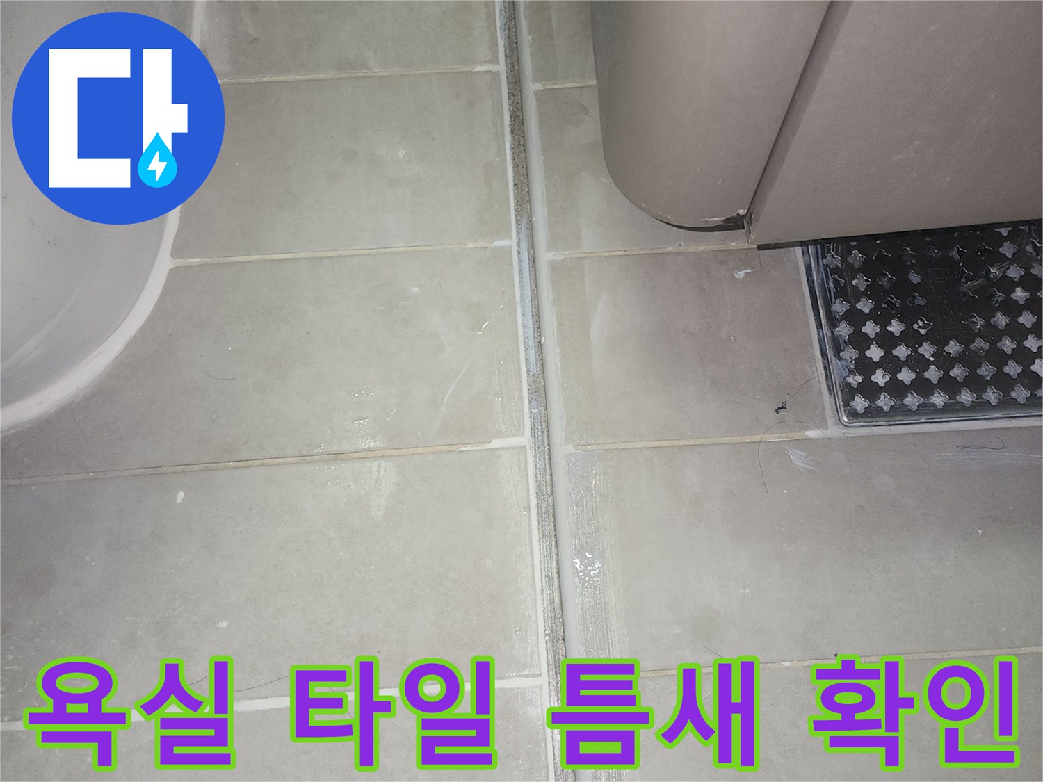 화장실 벽면 타일과 욕조 경계 부위의 줄눈 상태를 점검하는 모습입니다.
