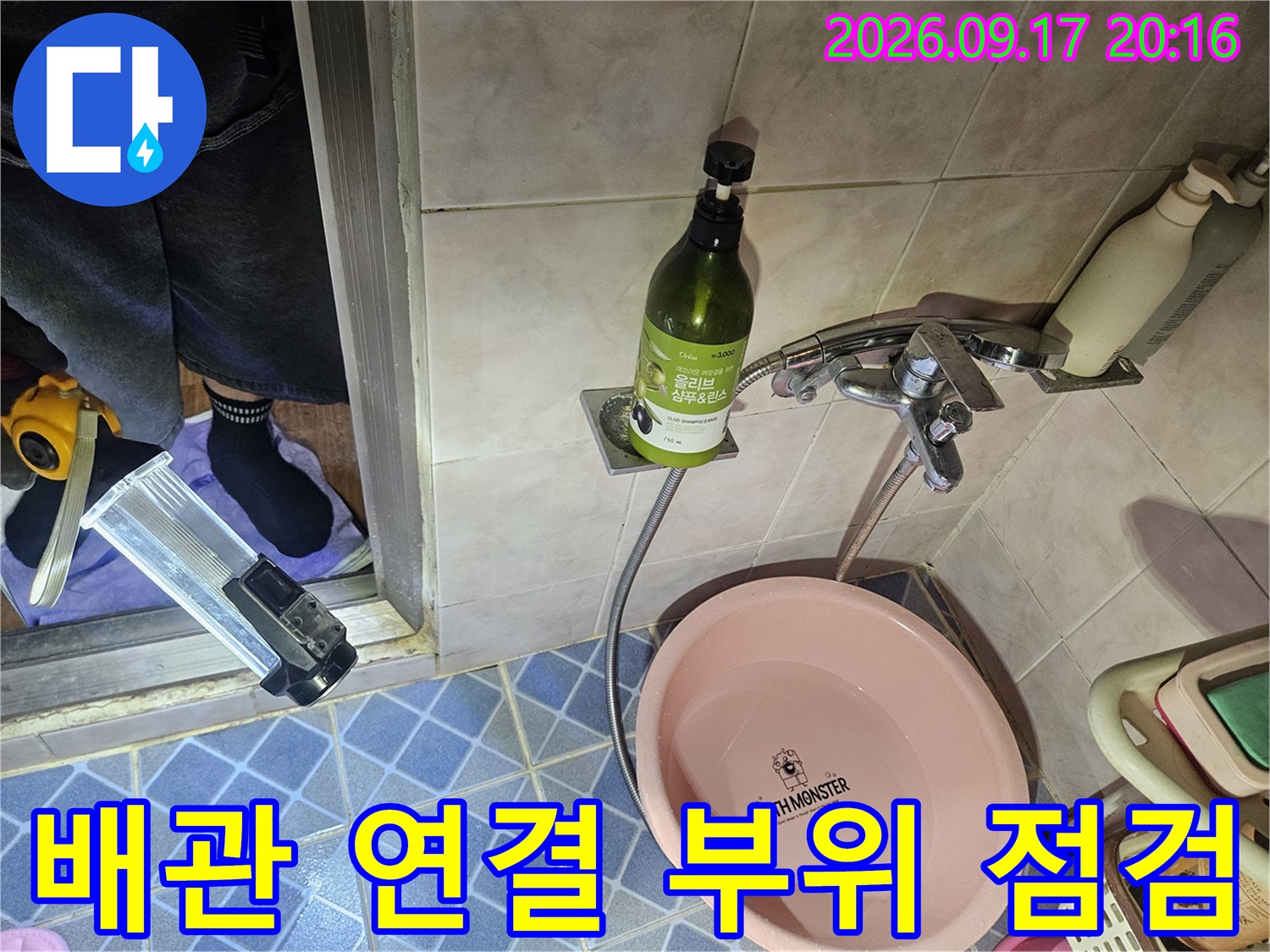 욕실 내 수전과 샤워 호스가 연결된 배관 하단부를 근접 촬영한 사진입니다.