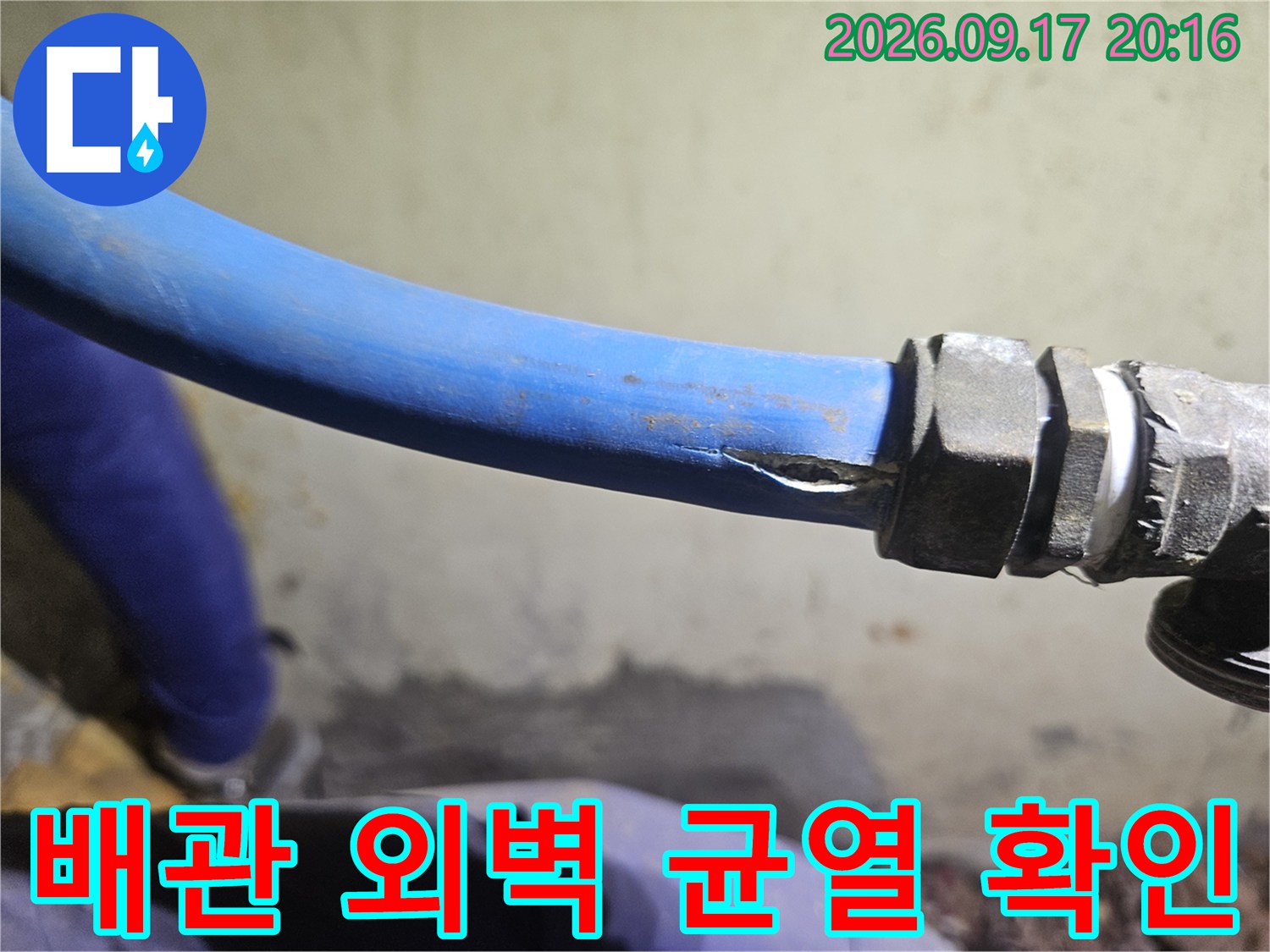 파란색 배관의 찢어진 부위를 근접 촬영한 사진입니다.