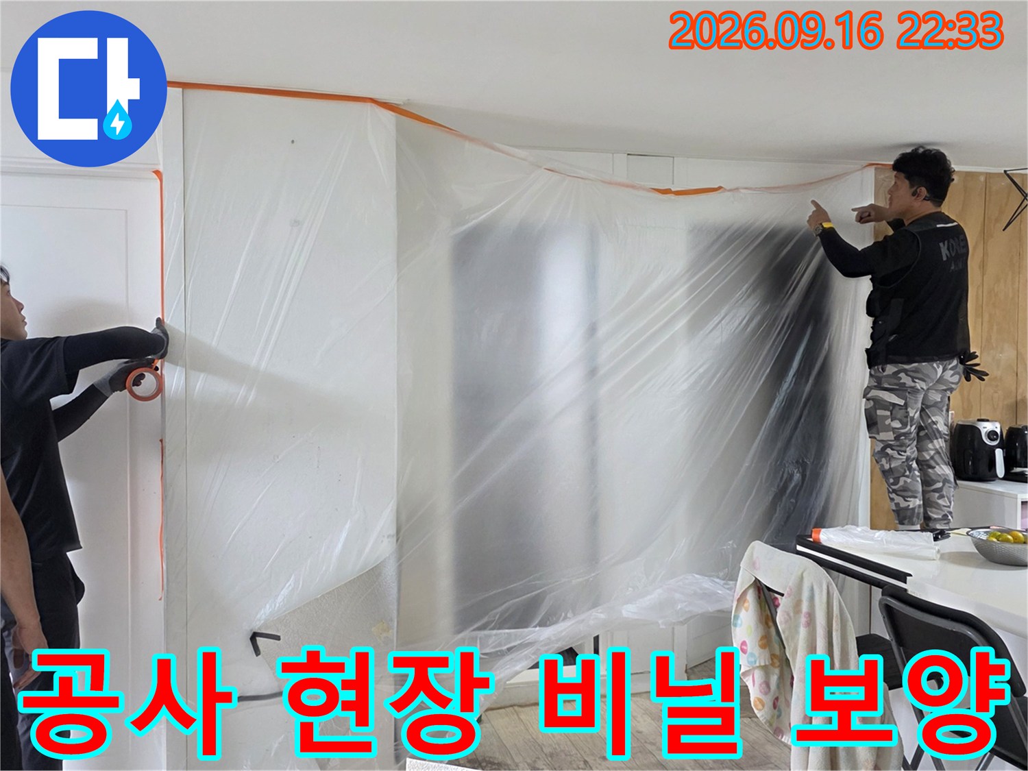 누수 공사 현장의 가구와 벽면을 보호하기 위해 설치된 비닐 보양 작업 모습입니다.
