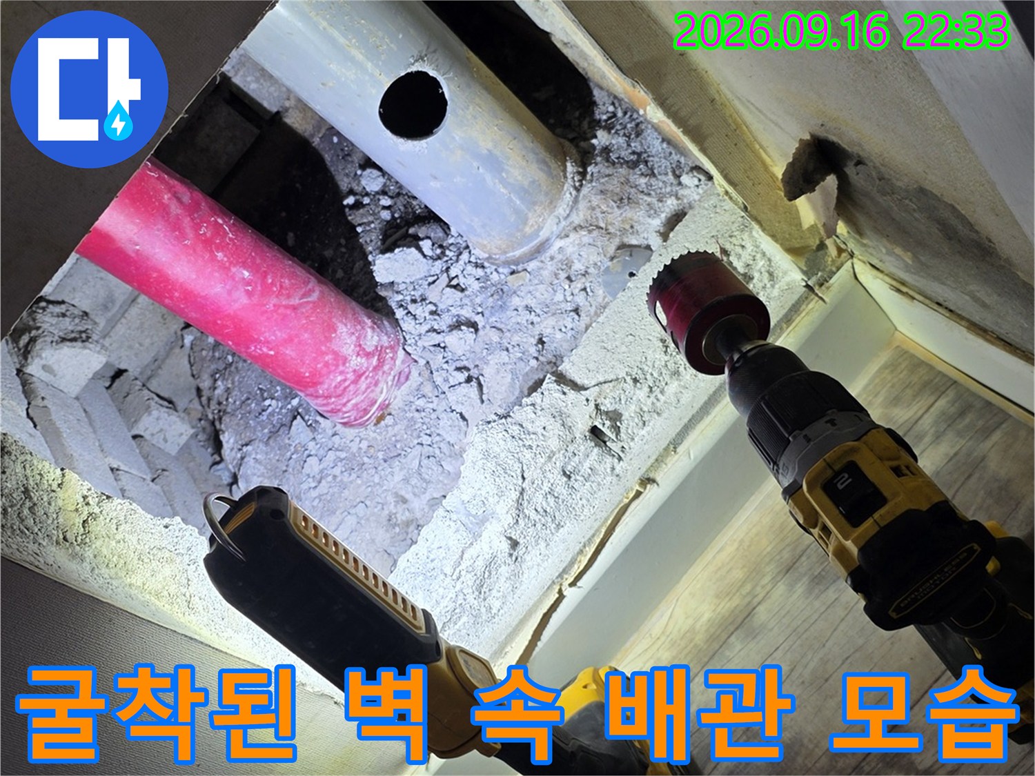 벽면을 뚫어 드러난 분홍색과 흰색의 매립 배관 상태